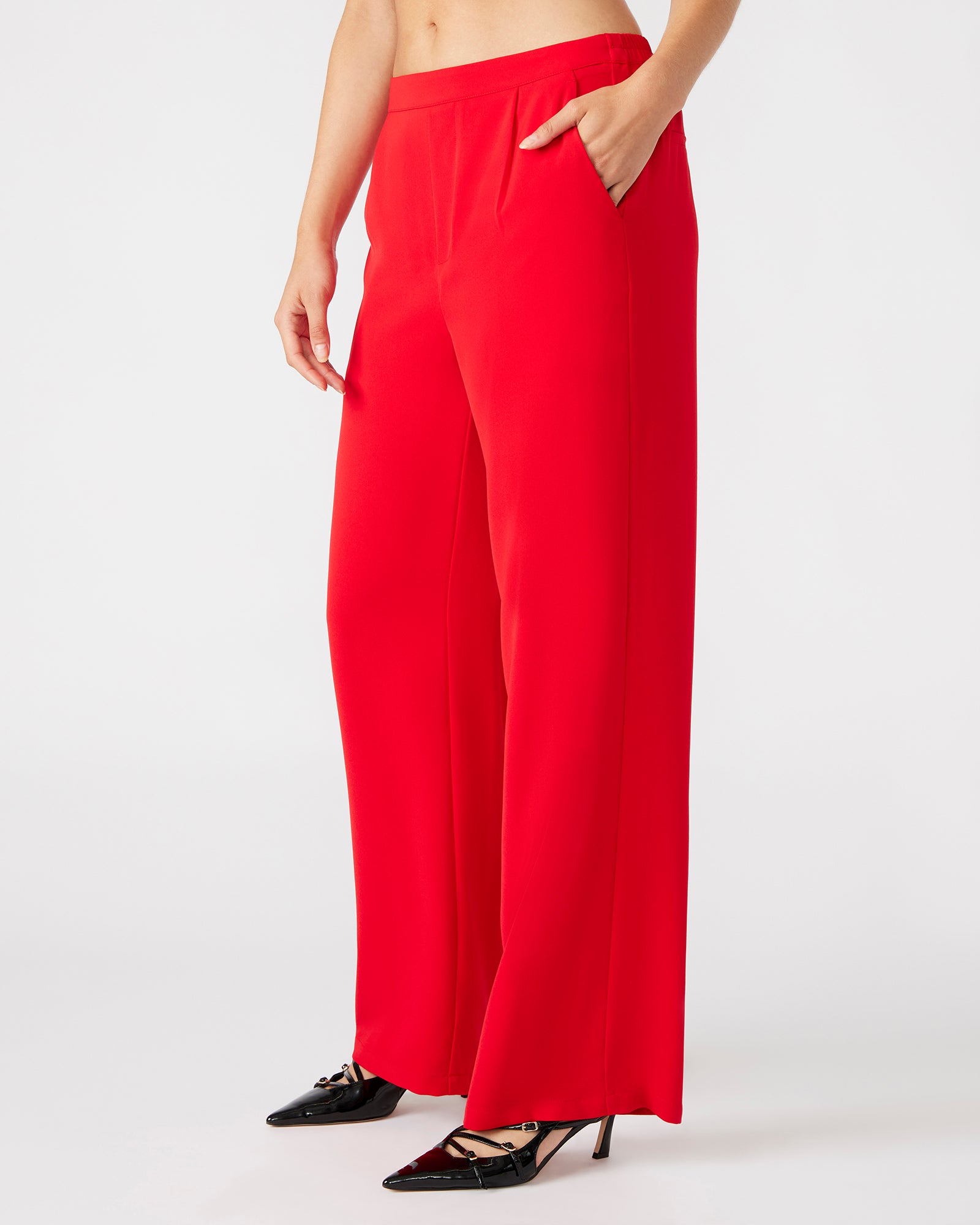 Close-up of the vibrant red wide leg trousers showcasing pleat details.