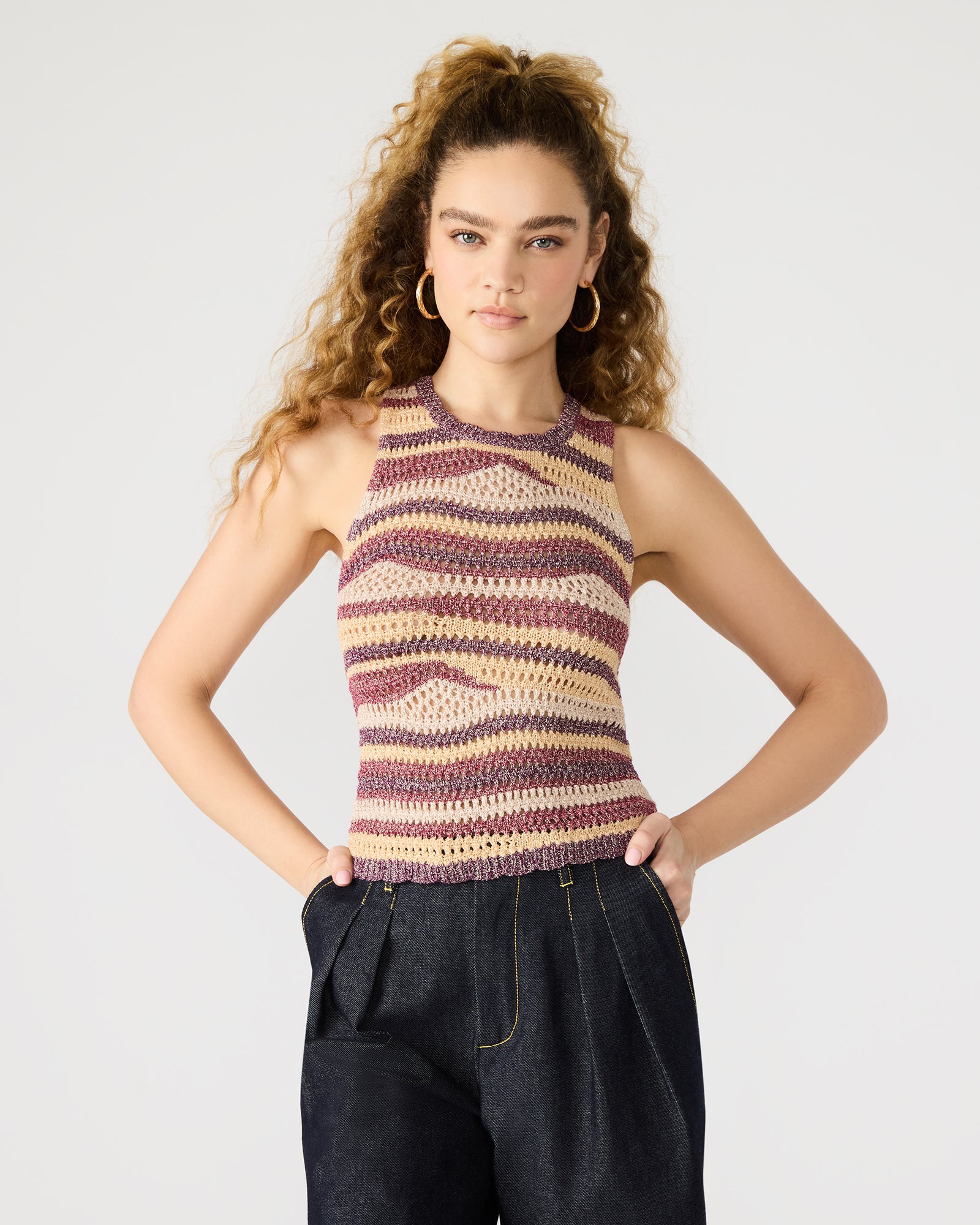 Front view of crochet tank top worn with high-rise jeans