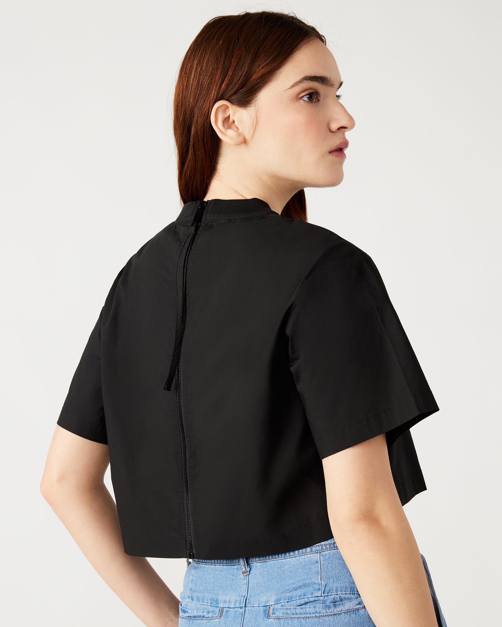 Front view of the chic boxy cropped t-shirt in black, showcasing the zipper detail.