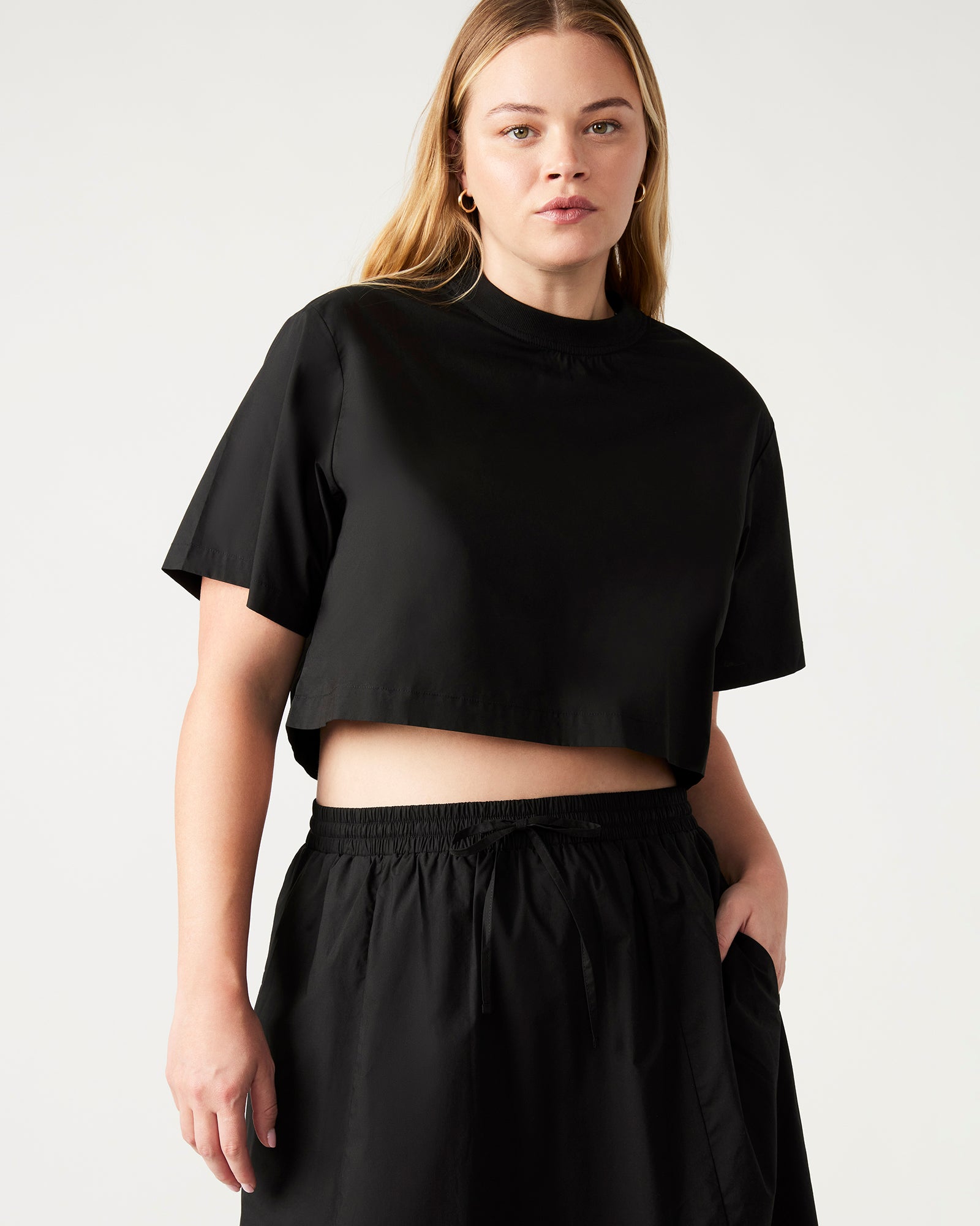 Front view of the chic boxy cropped t-shirt in black, showcasing the zipper detail.