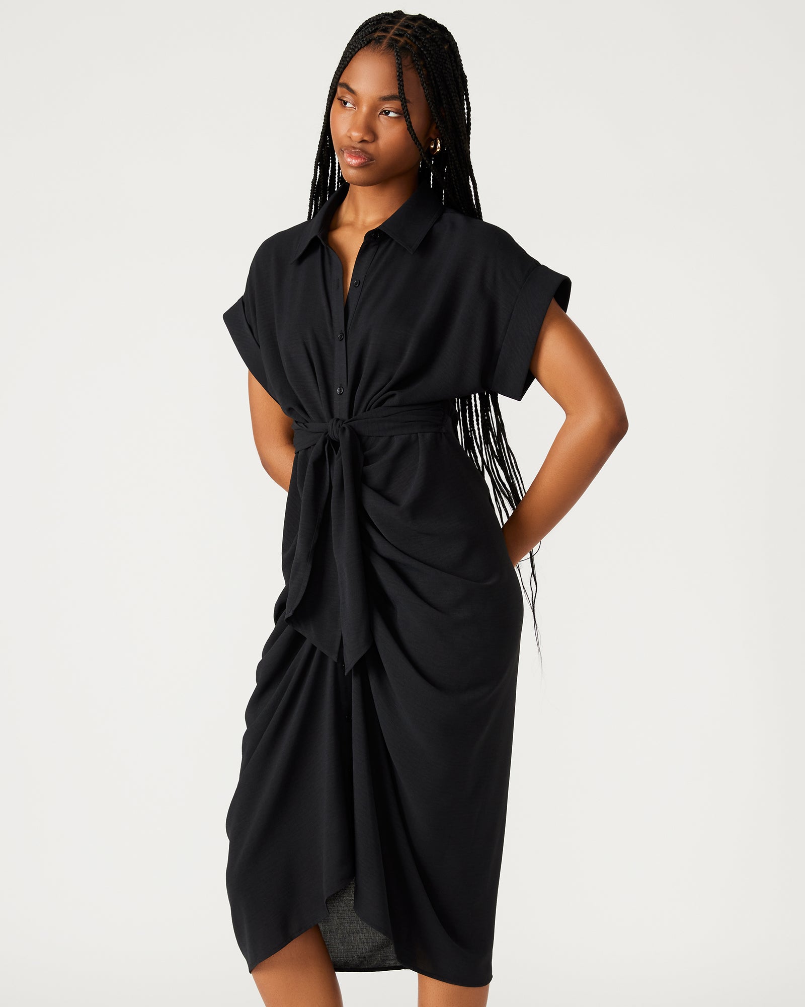Close-up of button-up closure and crepe fabric texture on midi black dress