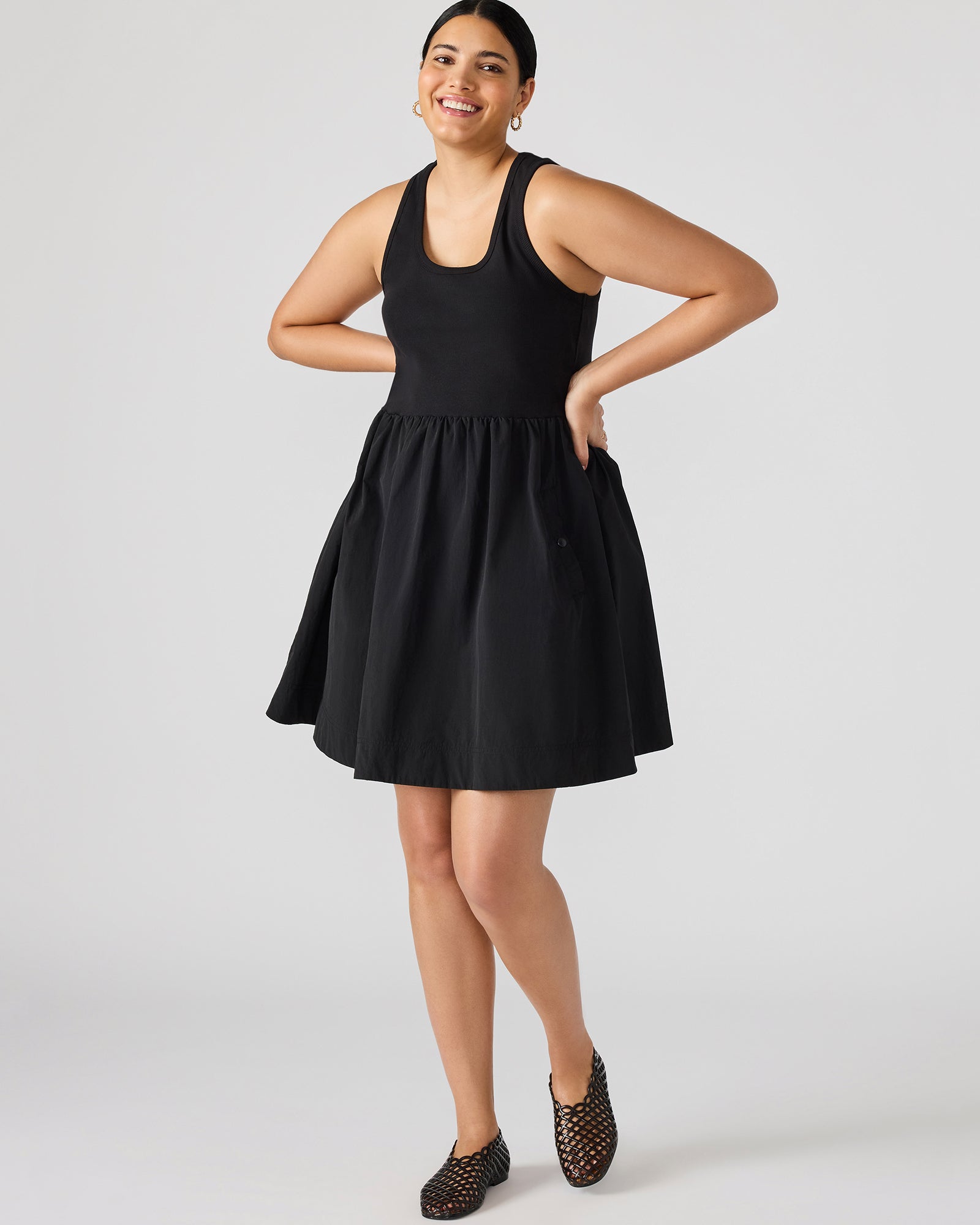 Side angle showing tank-style top and snap pockets on black ruffle dress