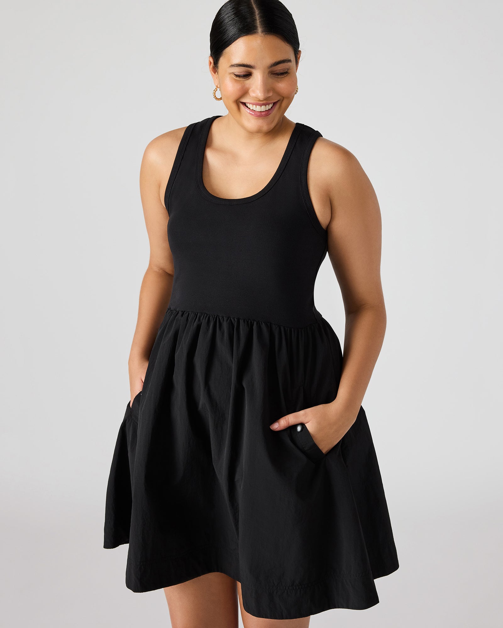 Model wearing black long sleeve mini dress layered over tank dress for cooler evenings