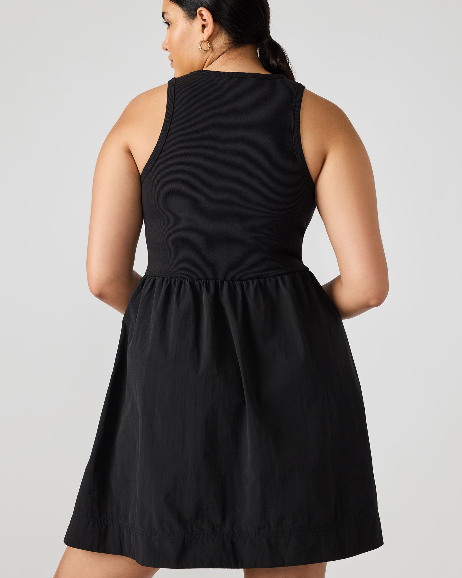 Front view of black mini dress with scoop neck and ruffle hem