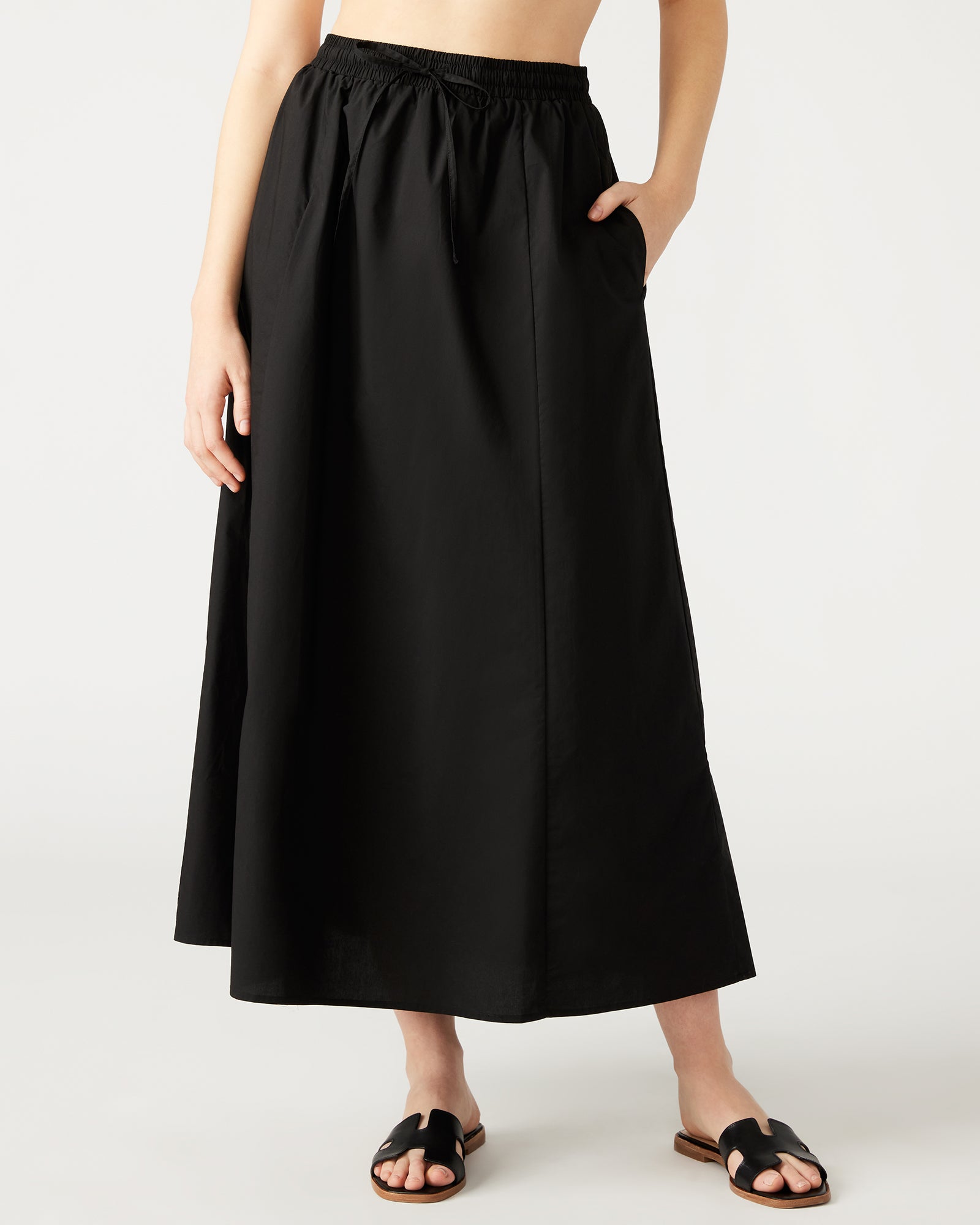 Full-length view of the black maxi skirt styled with a casual top