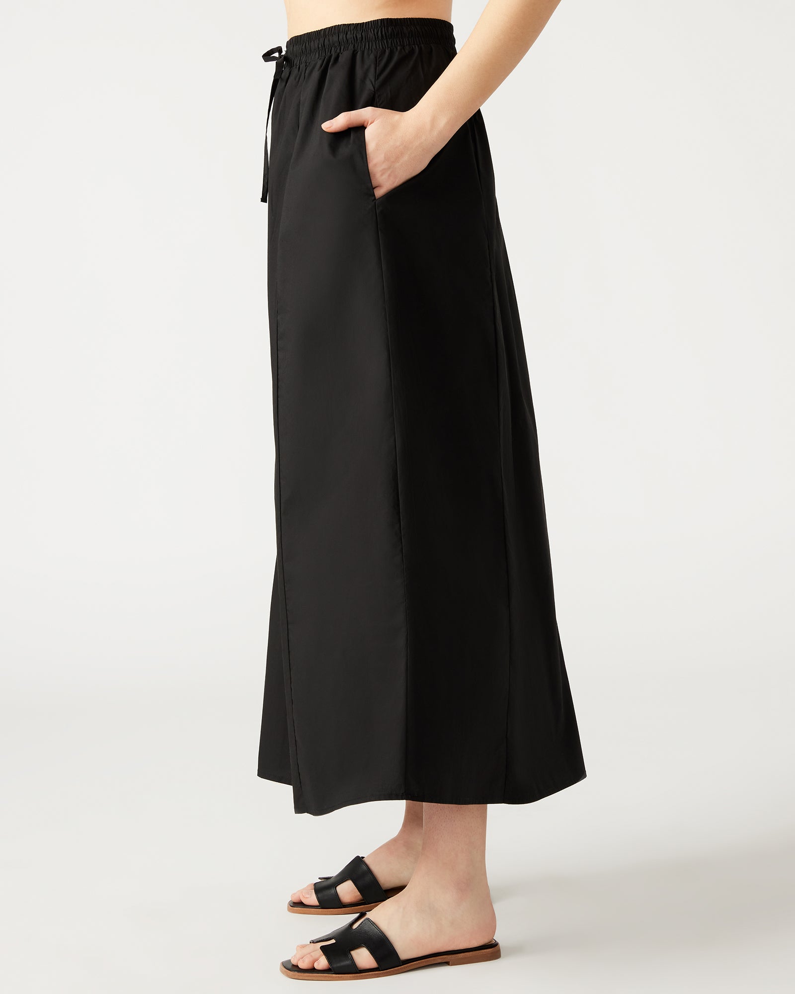 Close-up of the black maxi skirts side pockets and front tie detail