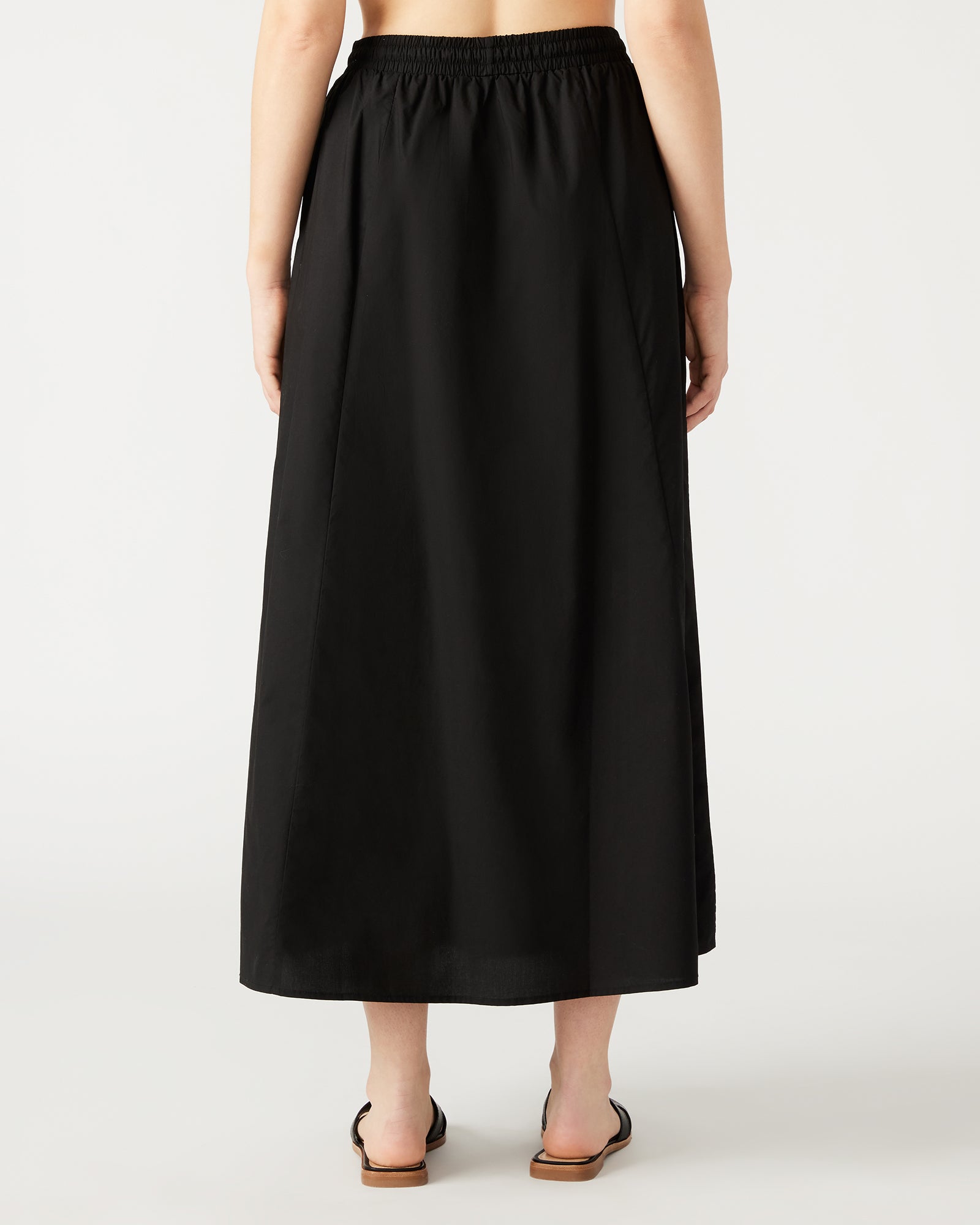 Model showcasing the flowing A-line silhouette of the black maxi skirt