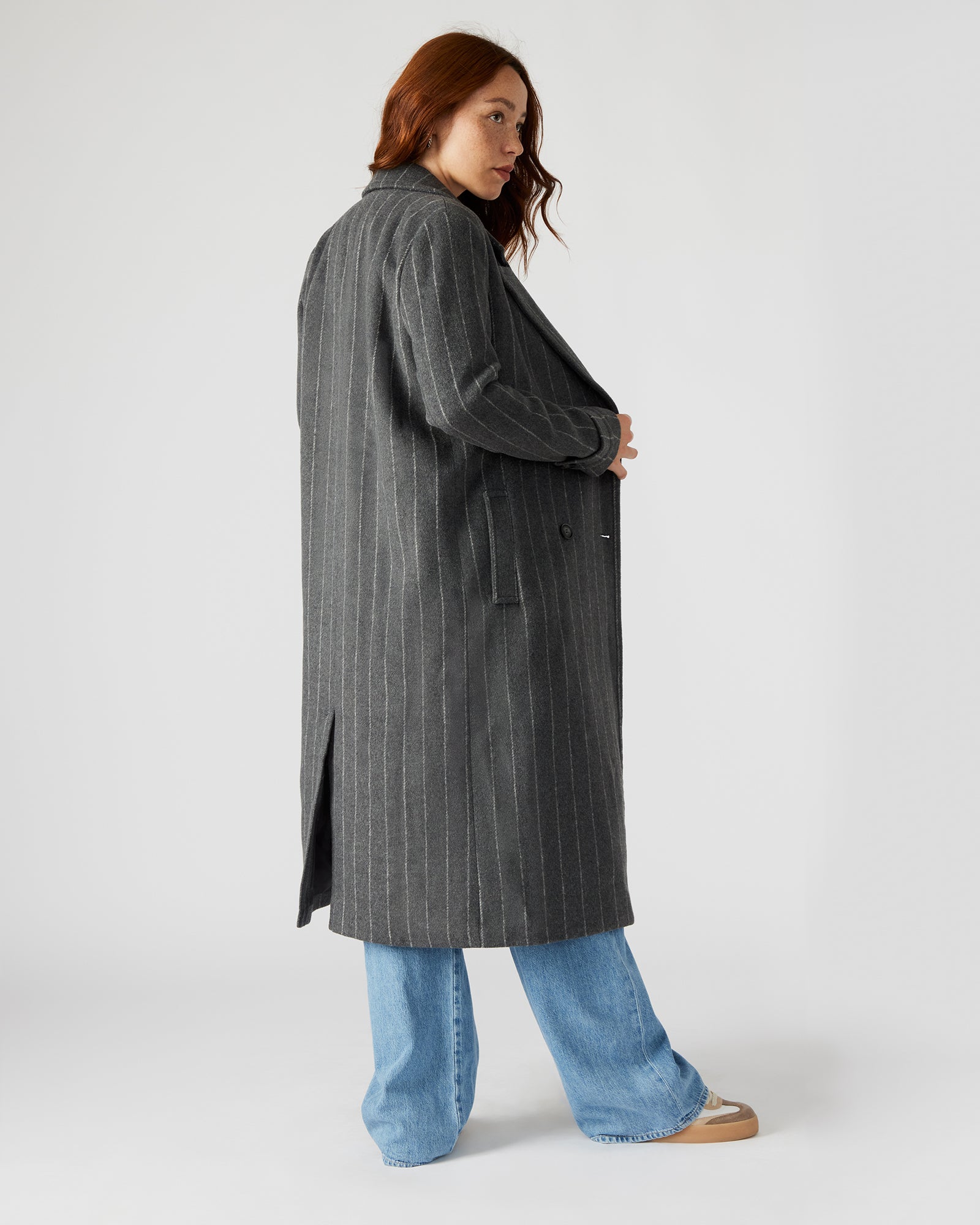 Model wearing a trench coat in a winter urban setting