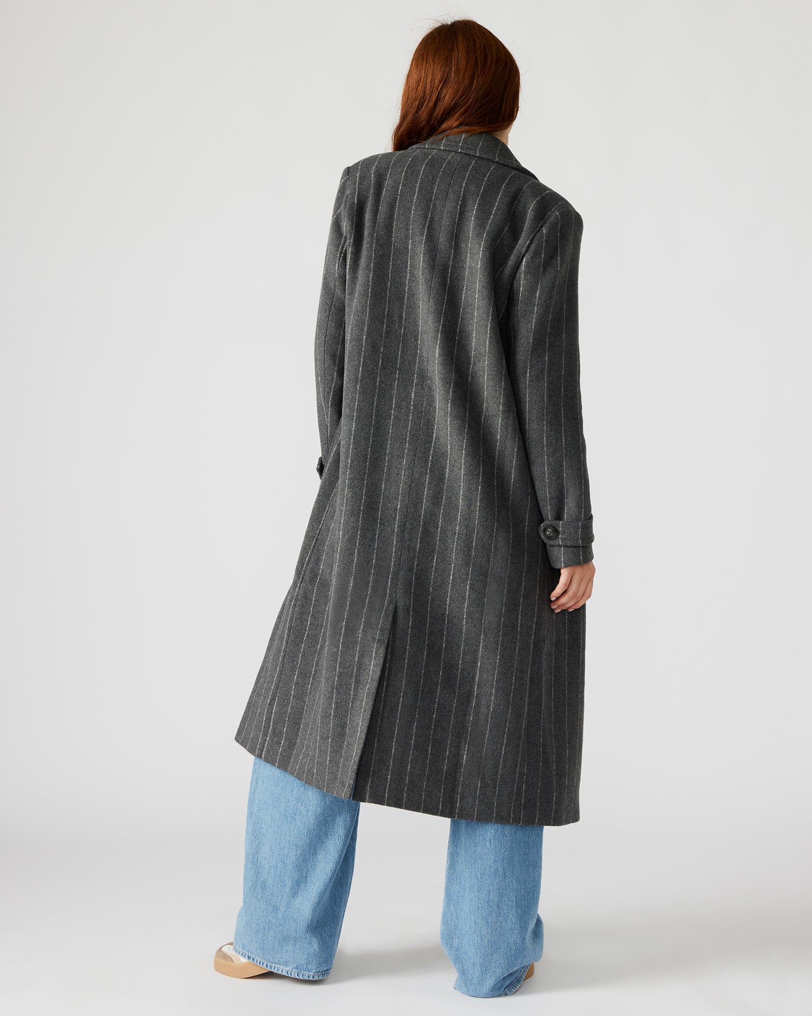 Front view of a pinstripe double-breasted trench coat on a model