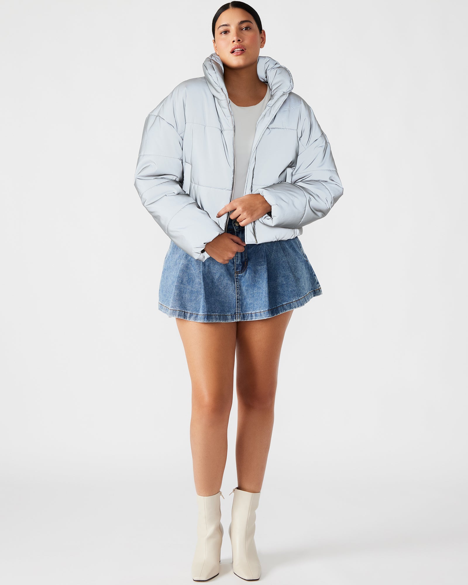 Model showcasing the reflective jacket in a city setting at dusk.