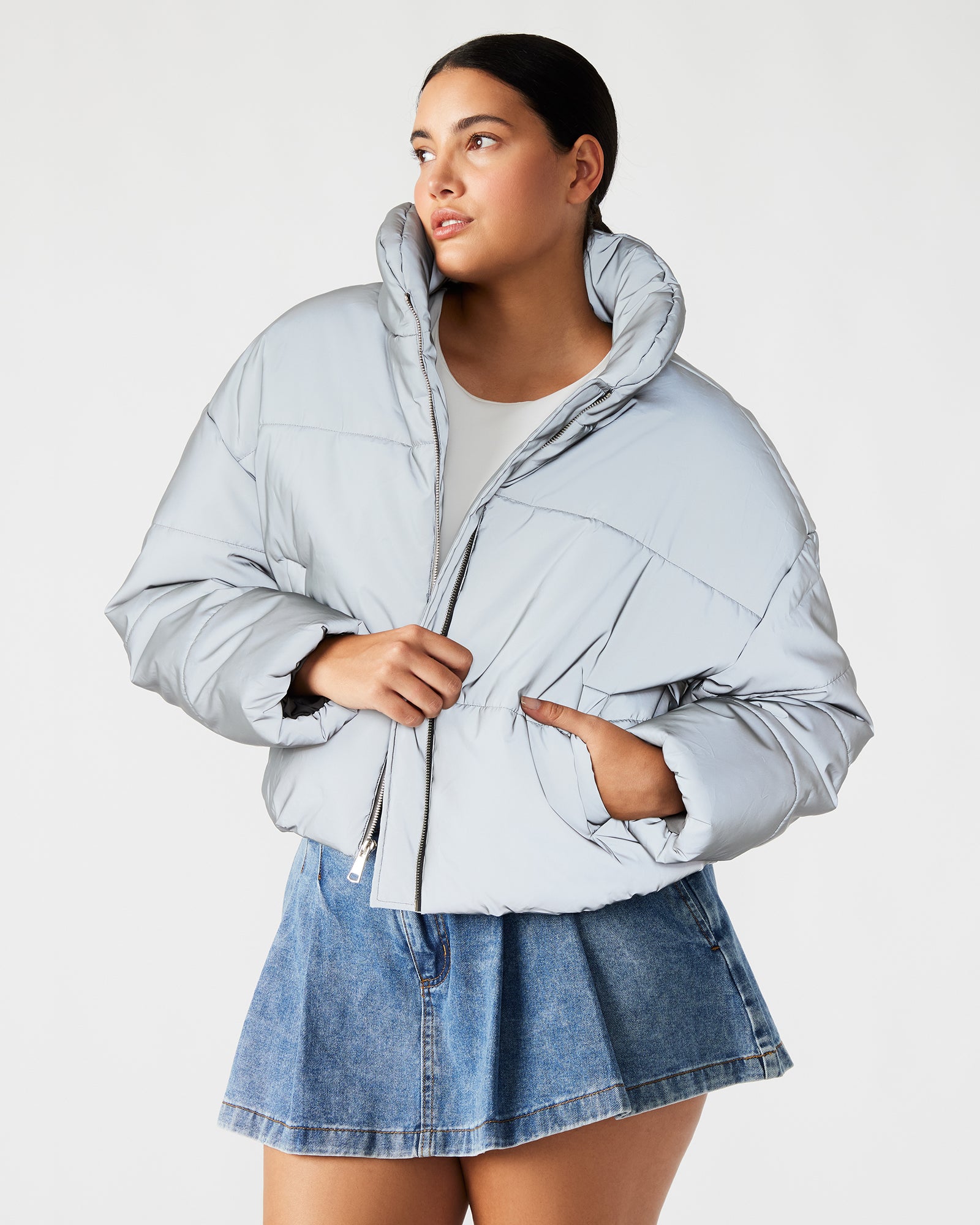 Model showcasing the reflective jacket in a city setting at dusk.