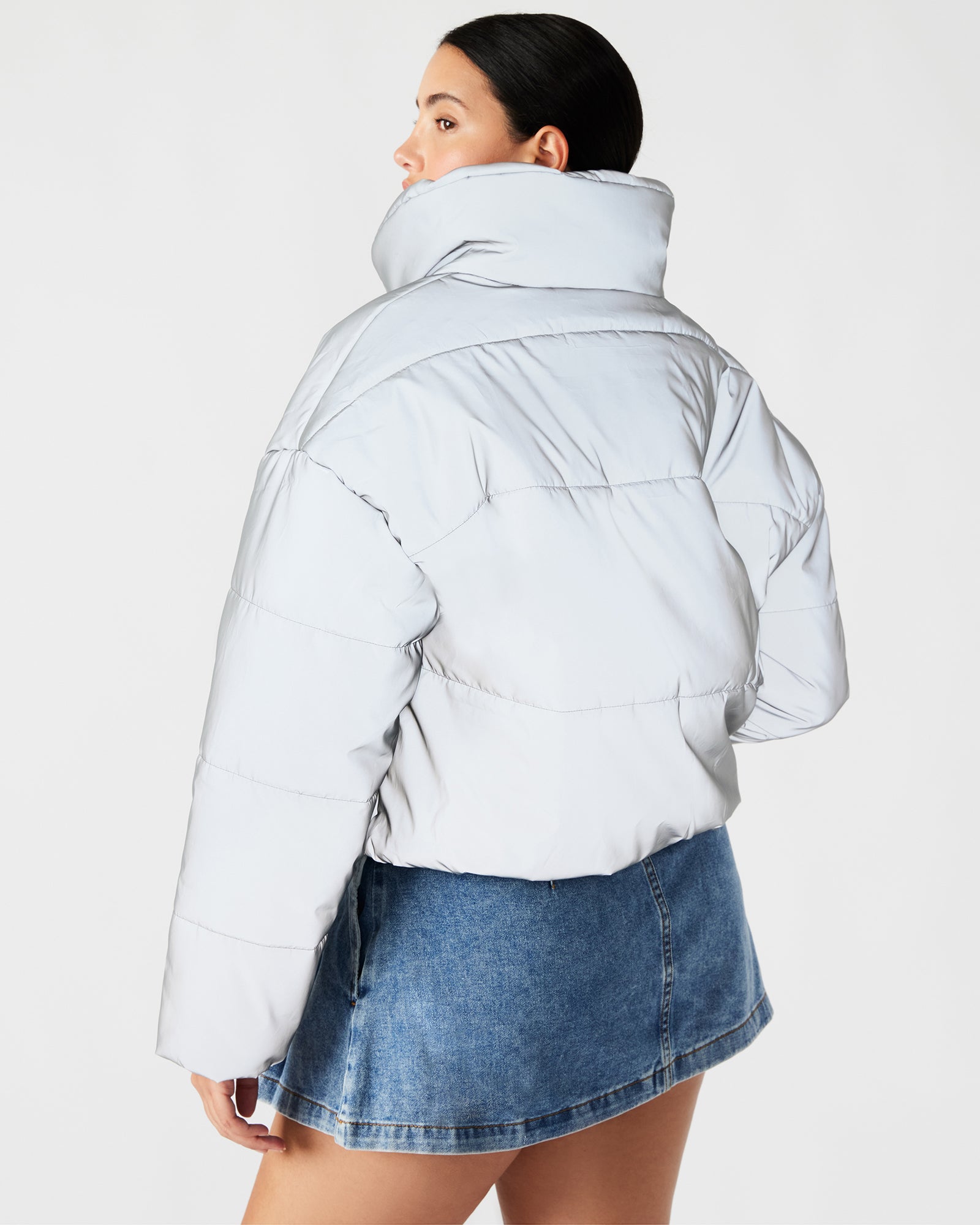 Close-up of the zipper guard on the silver reflective puffer jacket.
