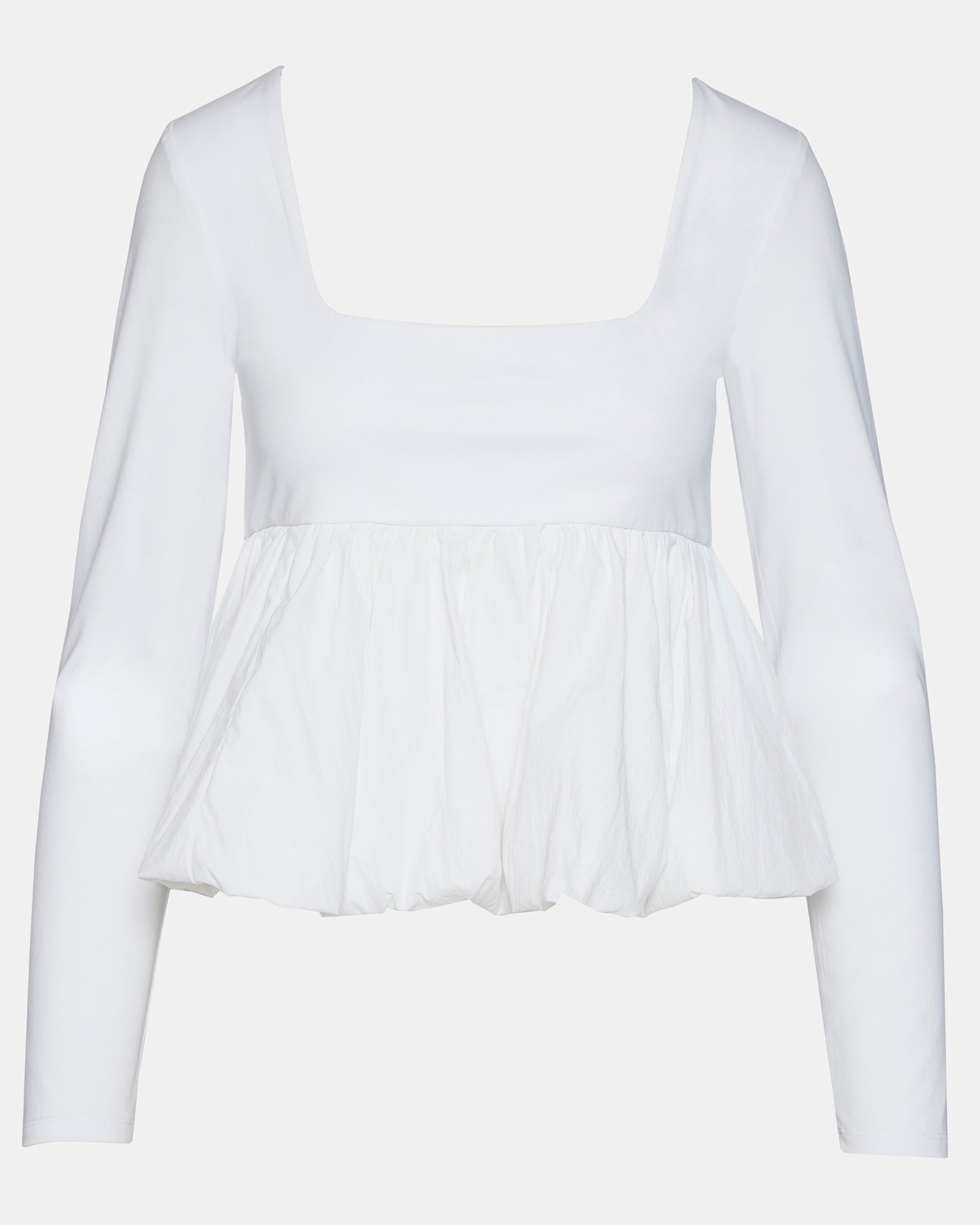 Model wearing a white peplum top with long sleeves for a sophisticated look