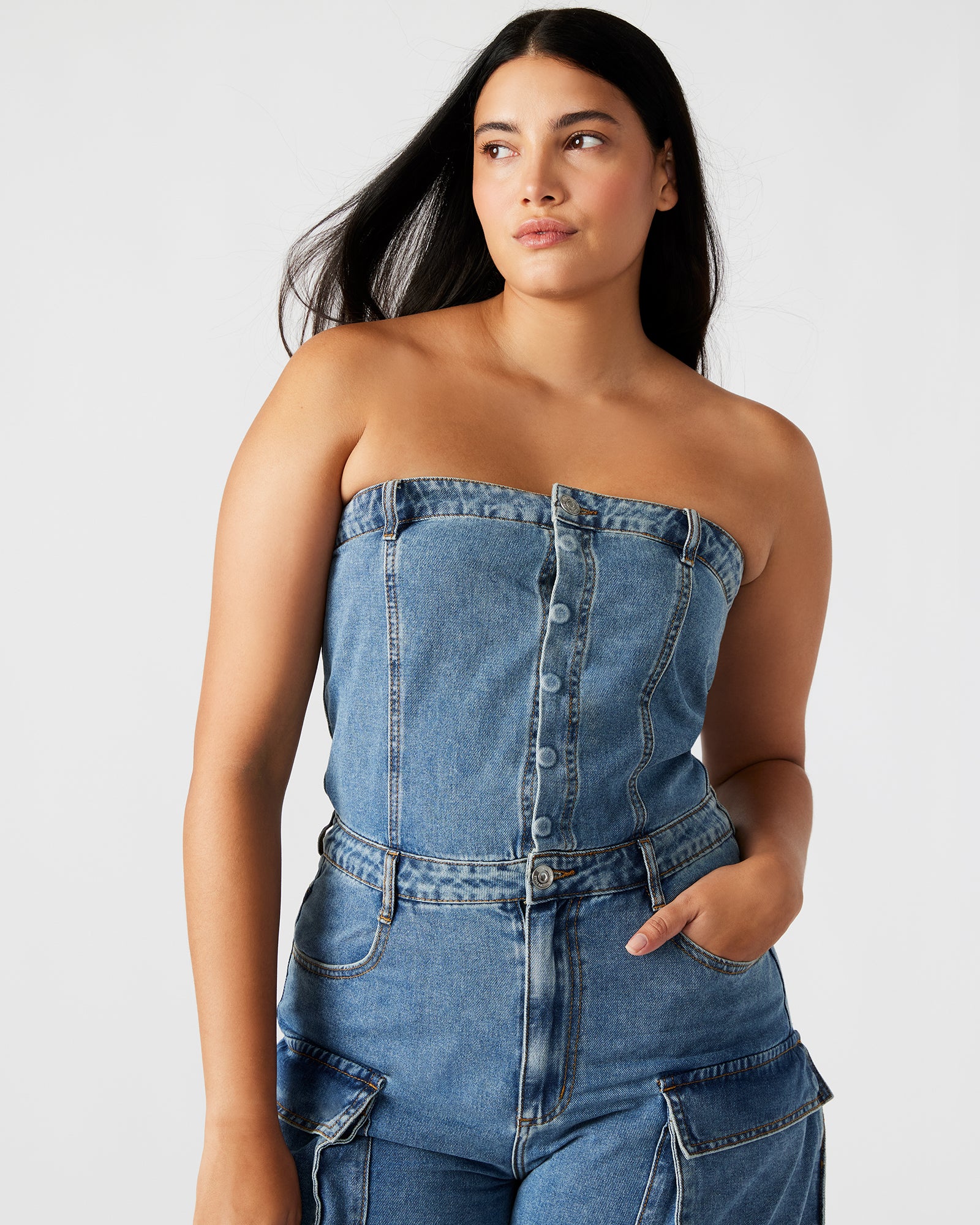 Close-up of the strapless denim jumpsuit showing cargo pockets and zipper details
