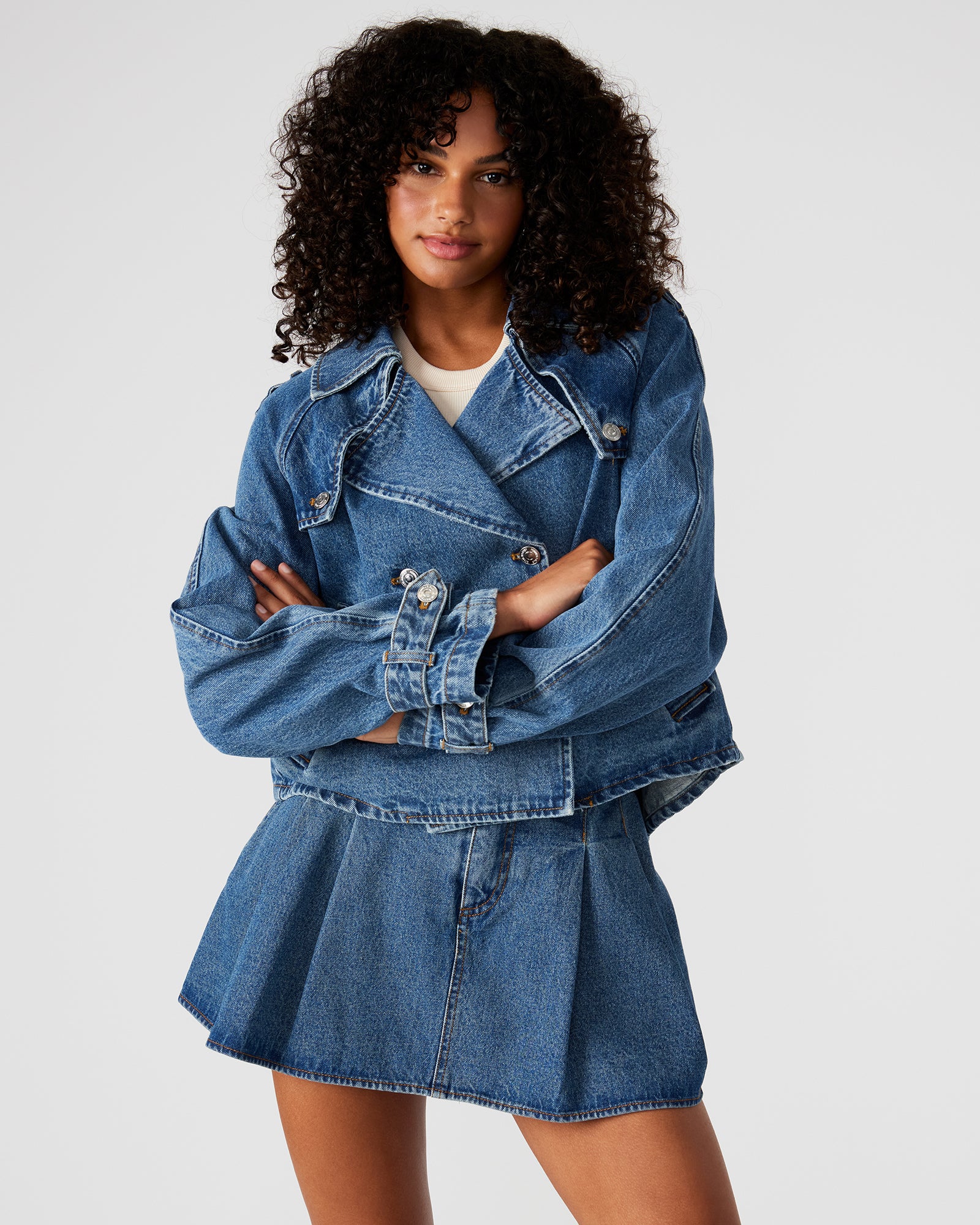 Back view of the SIRUS cropped denim jacket, showcasing the pleated back flap.