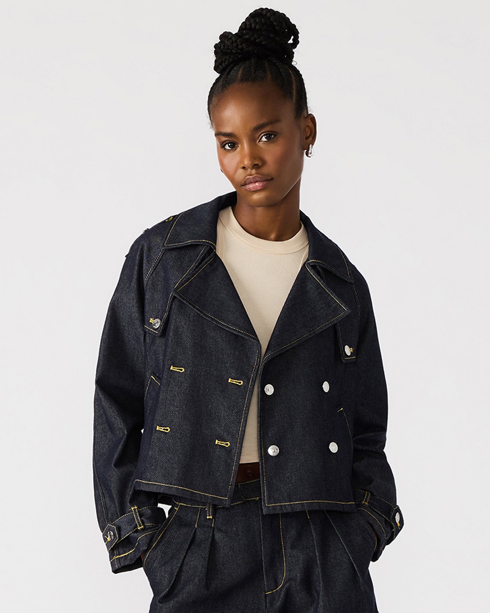 Front view of cropped indigo denim jacket showcasing double-breasted design.