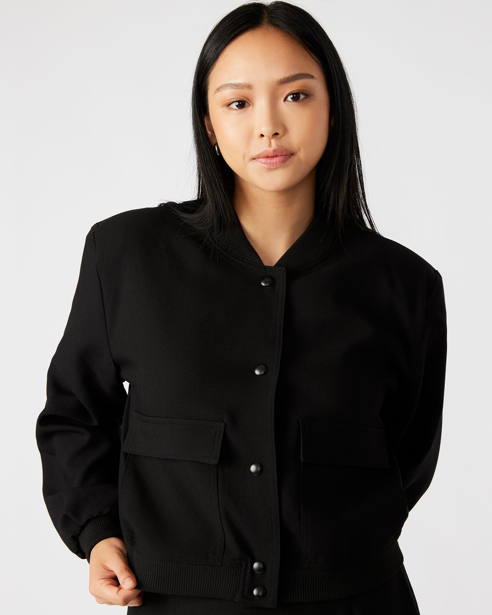 Close-up of the knit rib neckband and snap button closure.