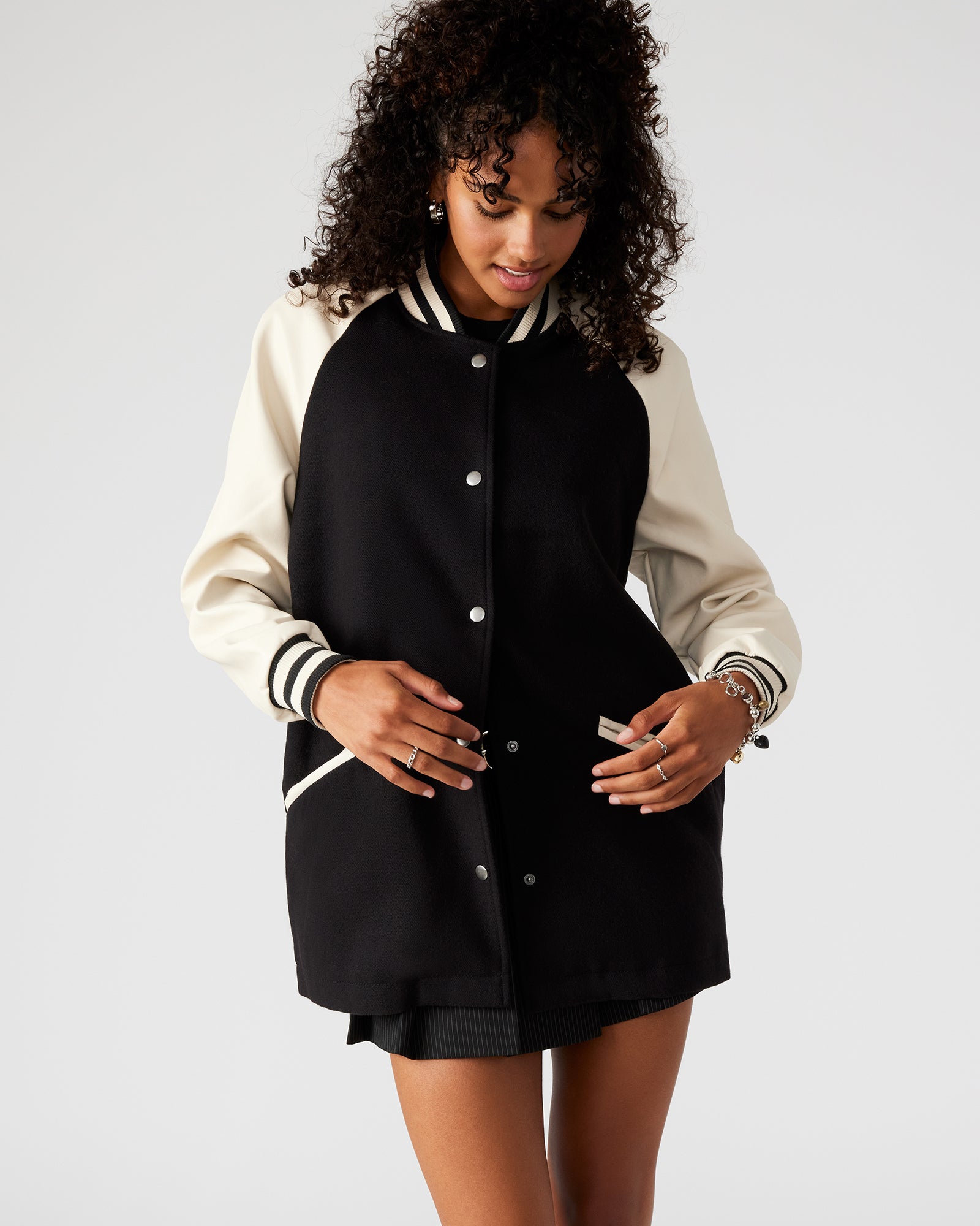 Model wearing the mens stadium jacket with rolled sleeves, urban backdrop