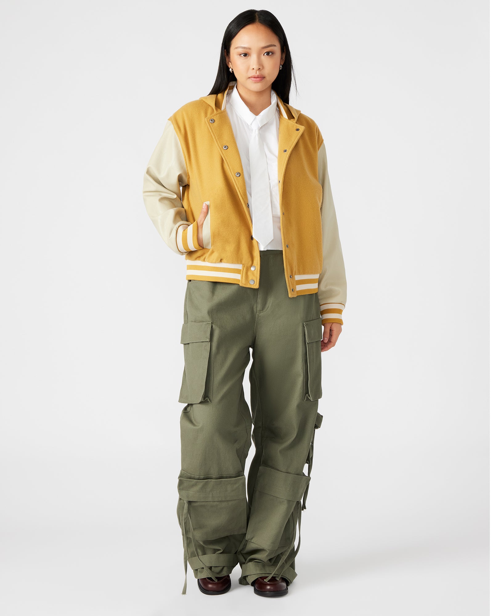 Model wearing the varsity jacket outdoors, showcasing its casual style
