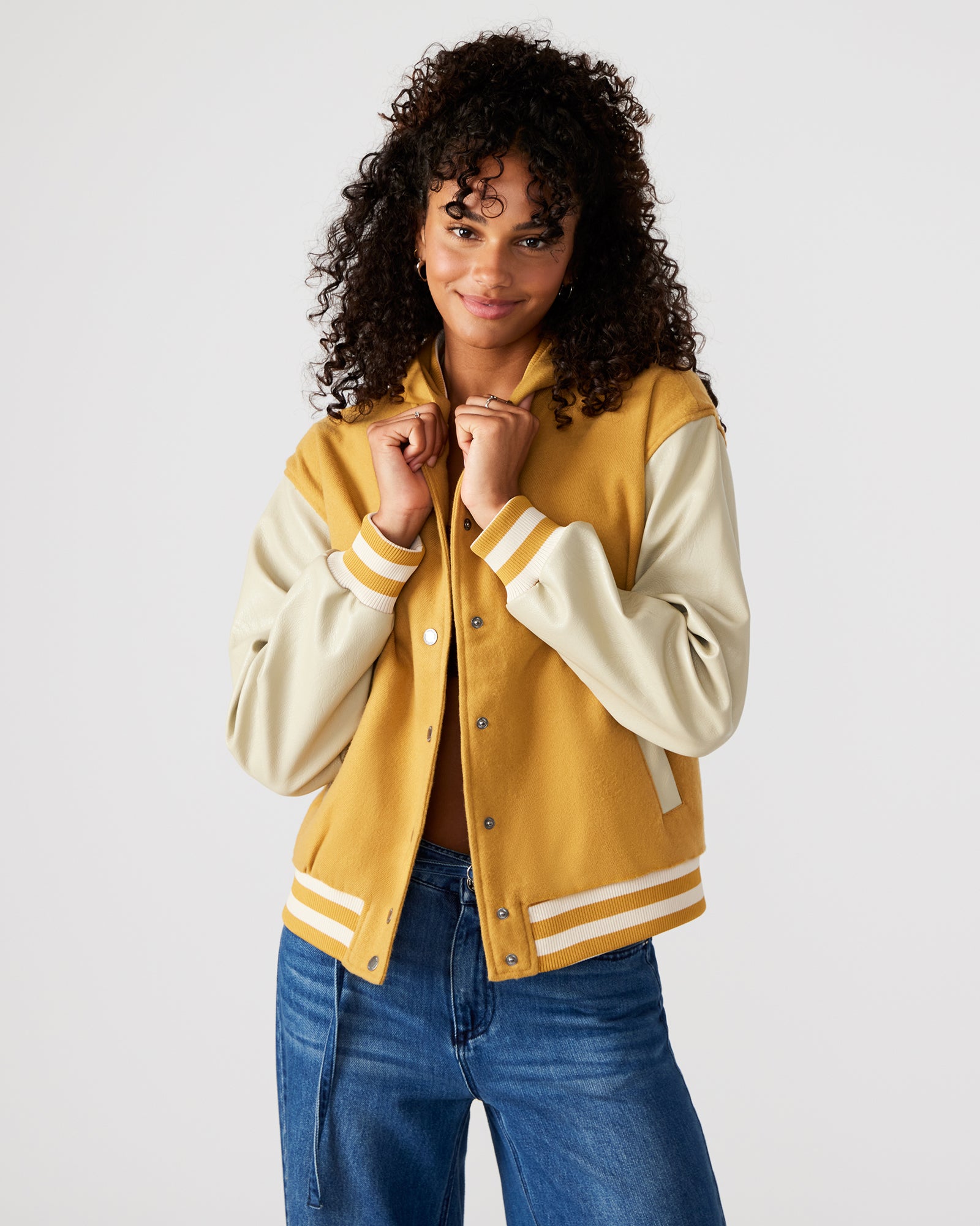 Model wearing the varsity jacket outdoors, showcasing its casual style