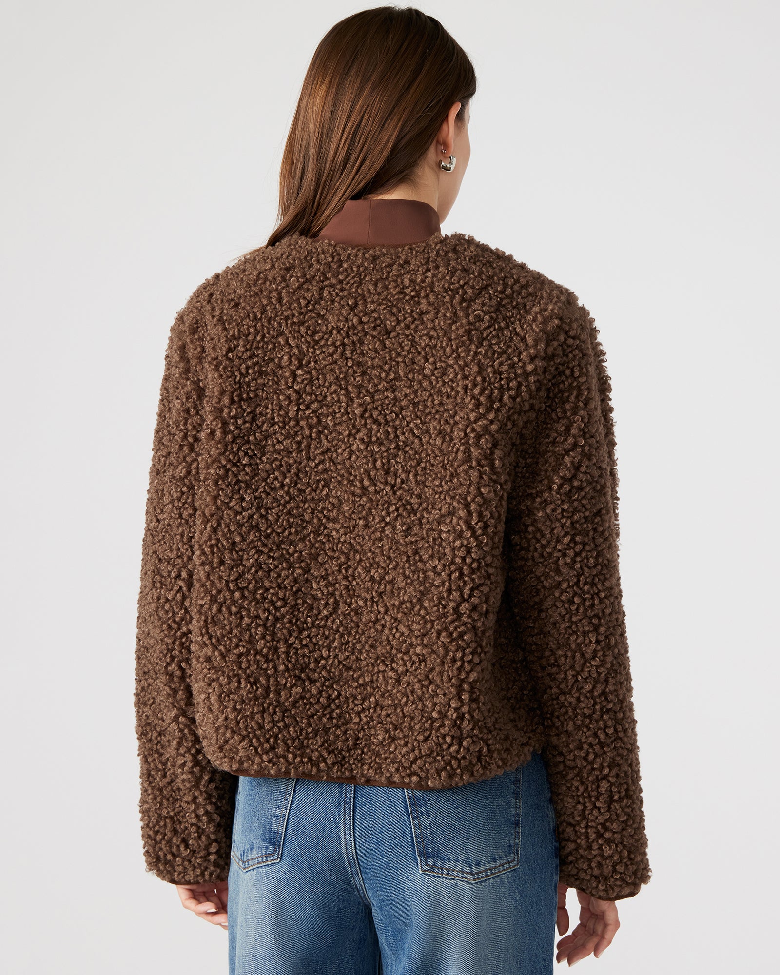 Close-up of the brown leather jackets zipper and sherpa collar detail