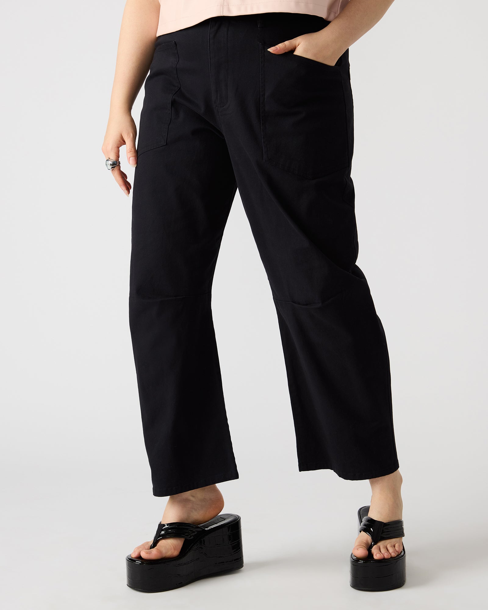 Front view of stylish cotton twill barrel leg pants in black, showcasing utility pockets.