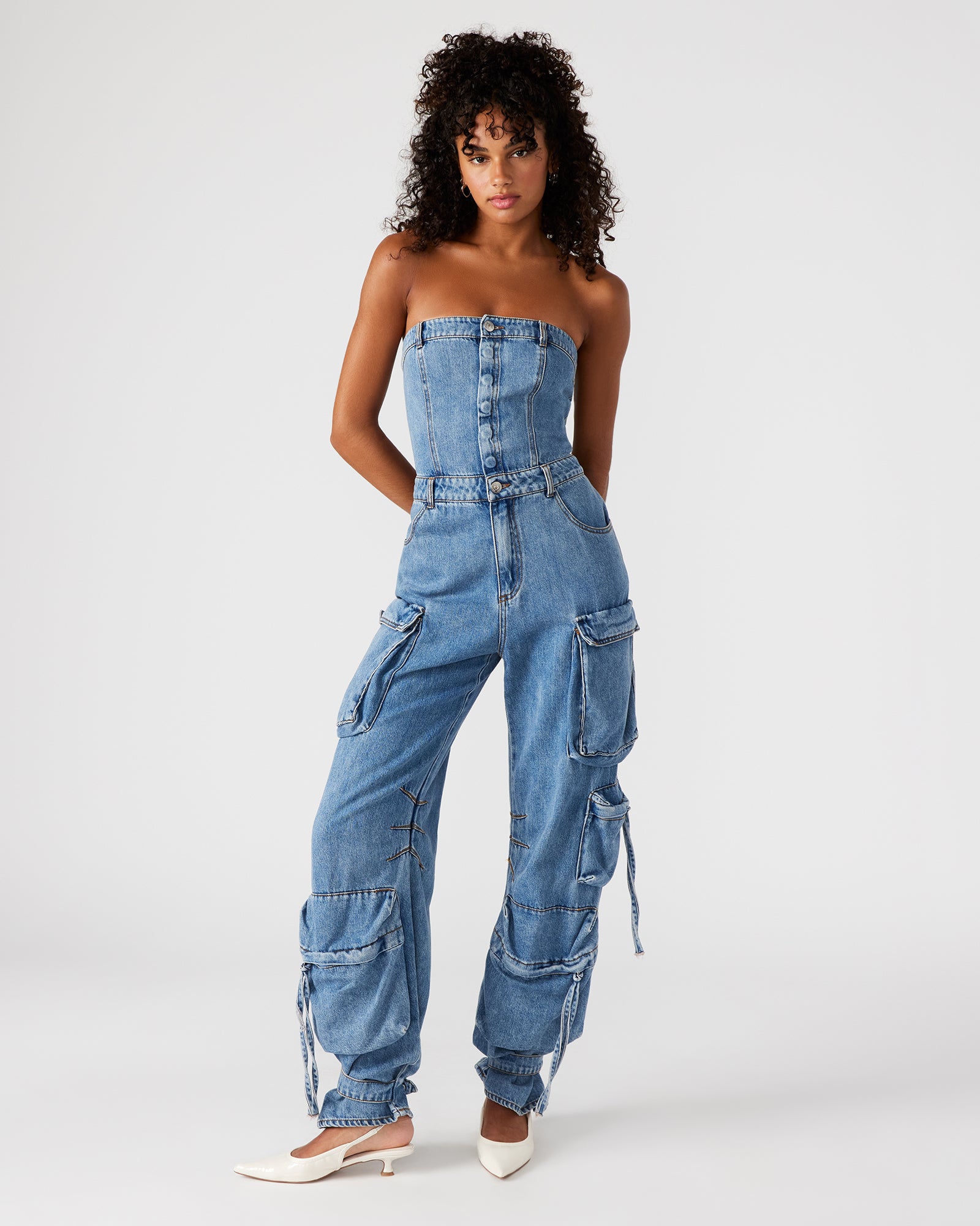 Close-up of the strapless denim jumpsuit showing cargo pockets and zipper details
