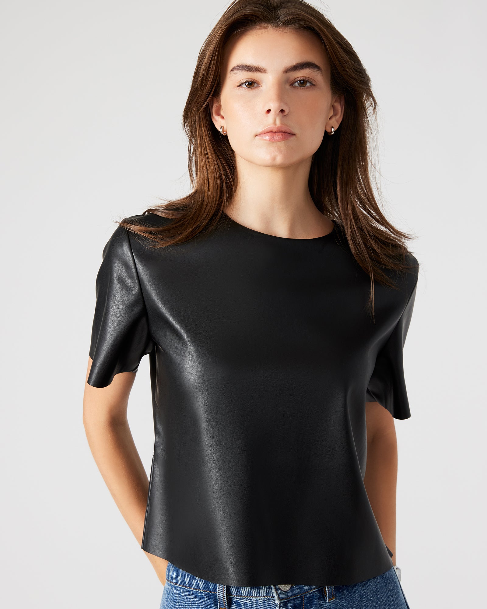 Model wearing the chic faux leather top in a casual setting.