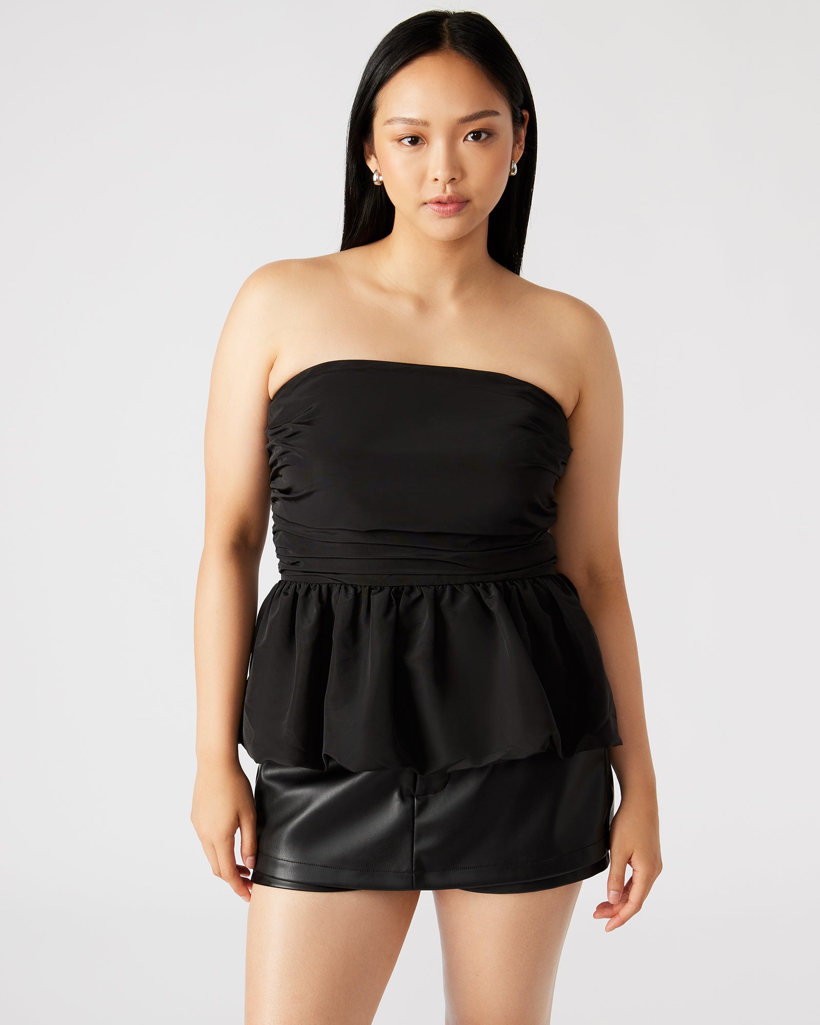 Front view of the chic peplum bubble hem top in black, showcasing its elegant design.
