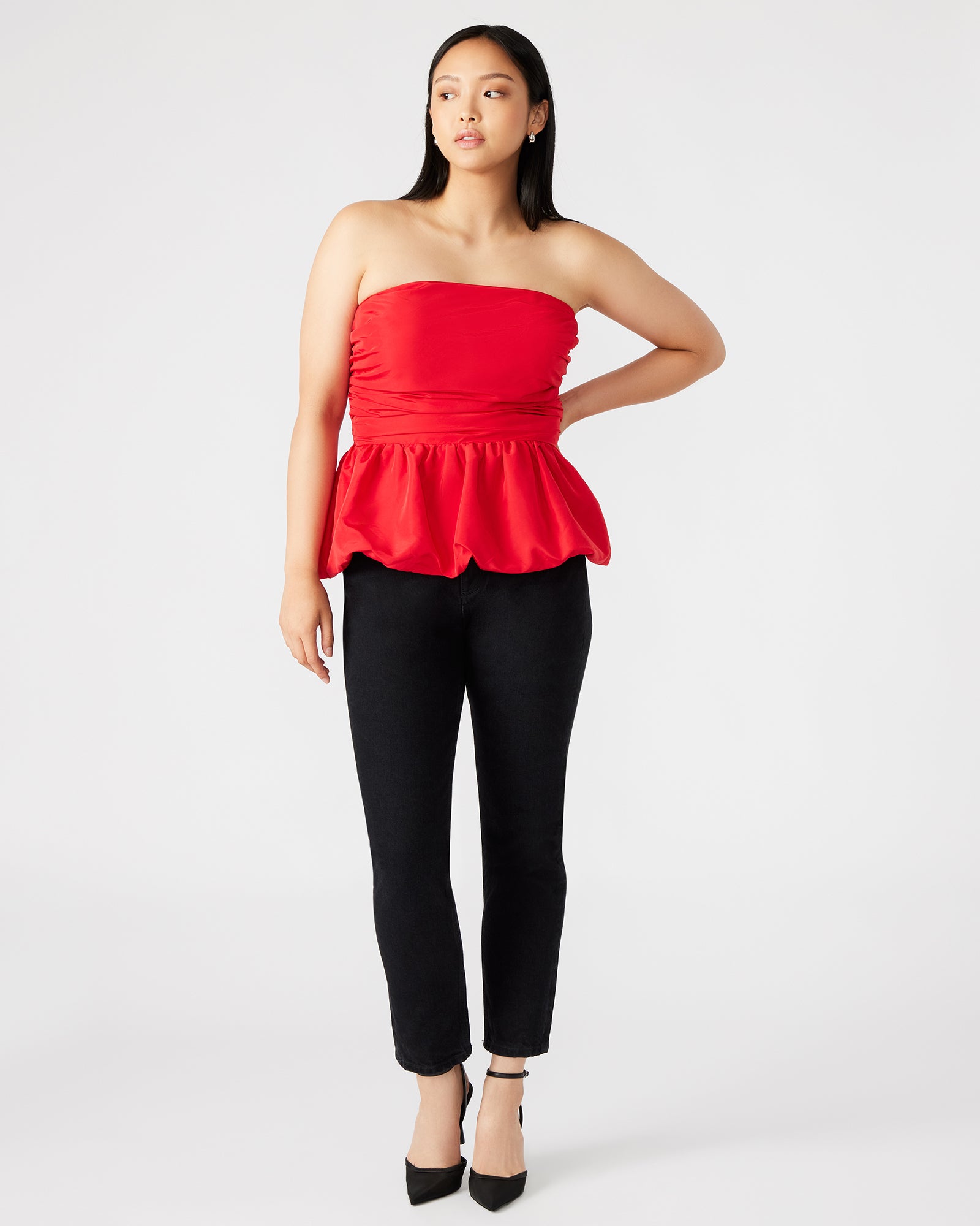 Side view of peplum top styled with linen pants, highlighting casual elegance