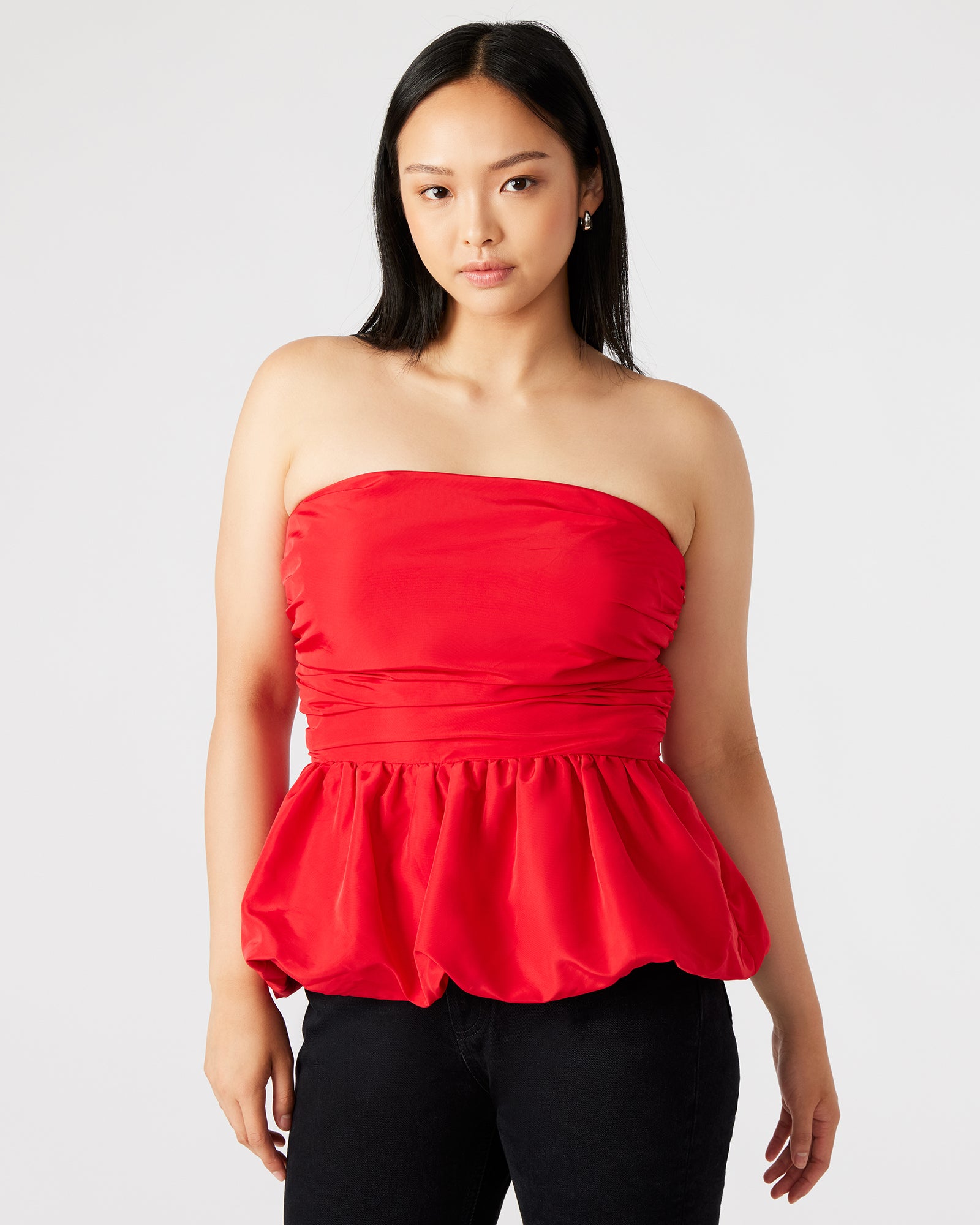 Side view of peplum top styled with linen pants, highlighting casual elegance