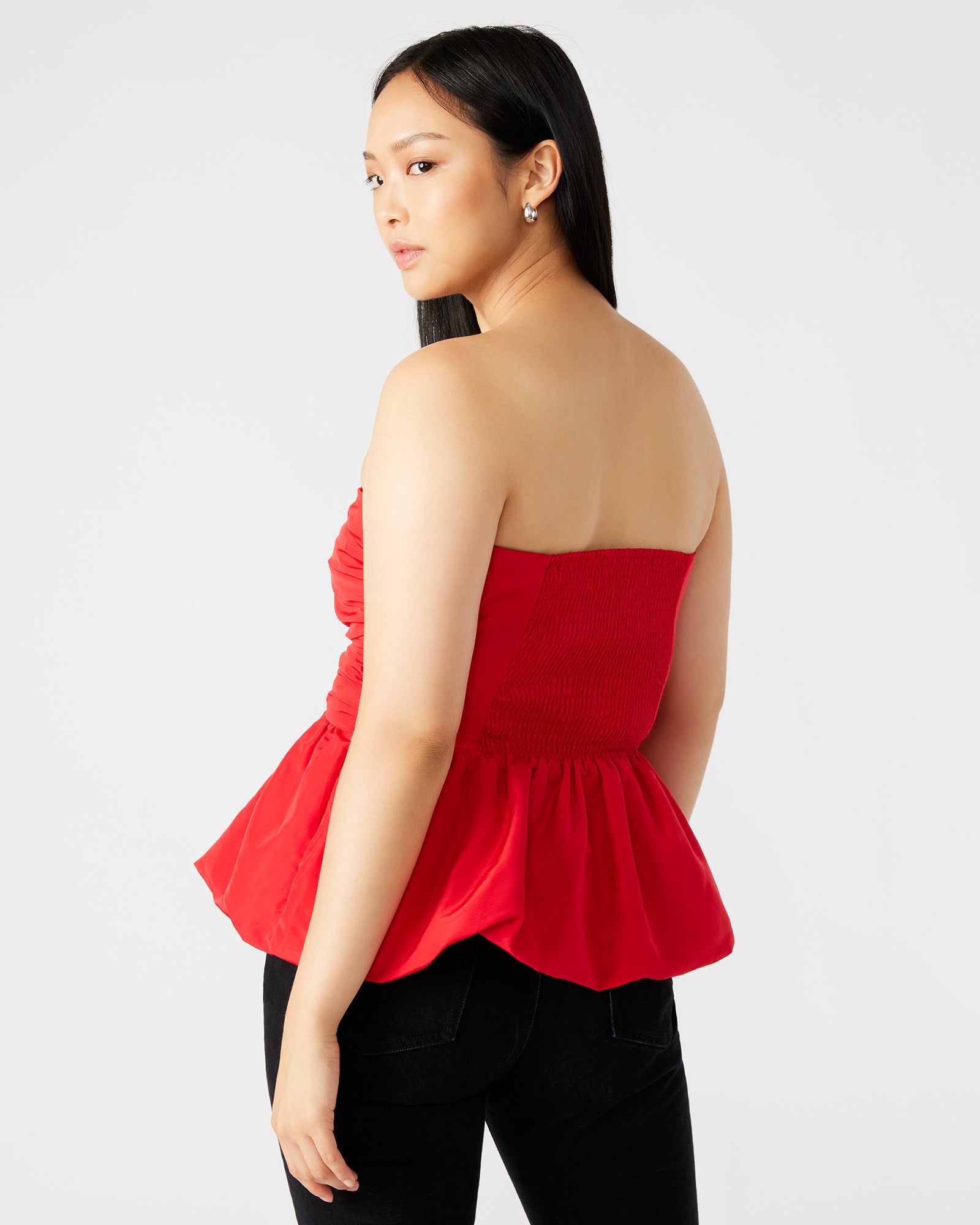 Front angle of white strapless top showing bubble hem and soft peplum detail