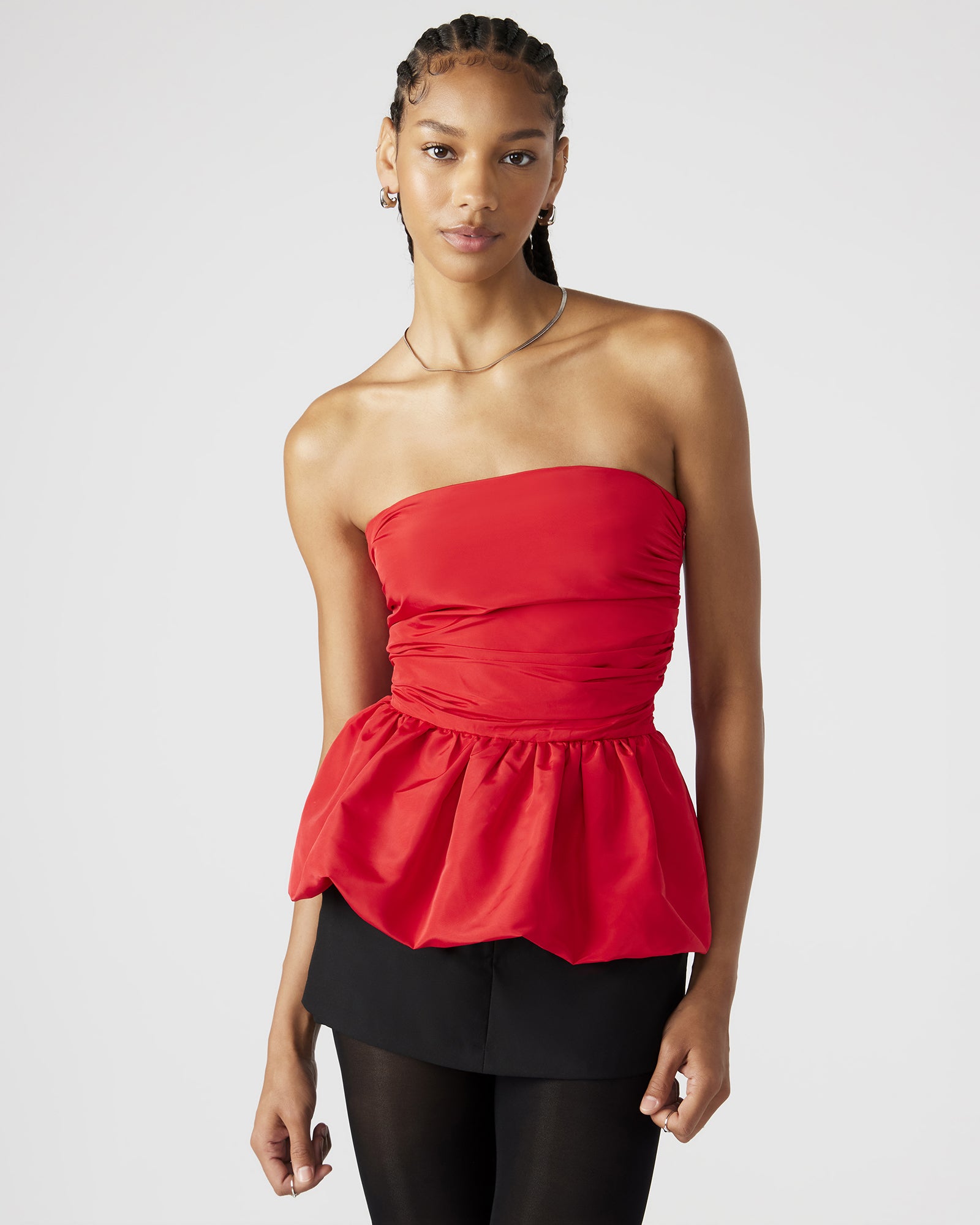 Front angle of white strapless top showing bubble hem and soft peplum detail