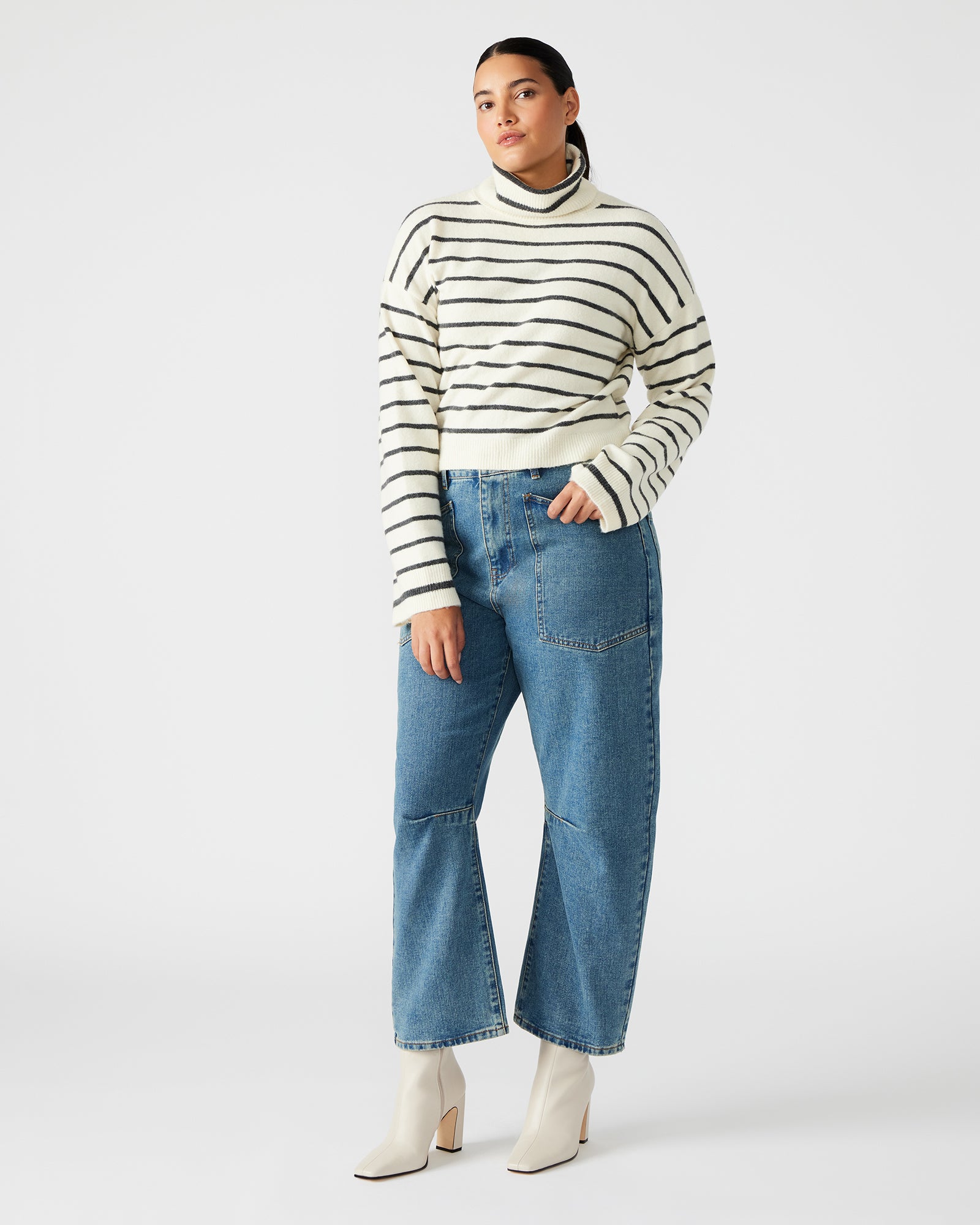Front view of the chic black and white striped turtleneck sweater, showcasing flare sleeves.