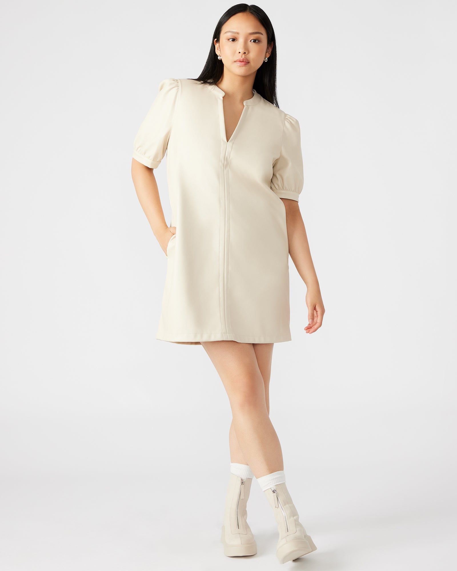 Front angle of white puff sleeve mini dress with v-neck design