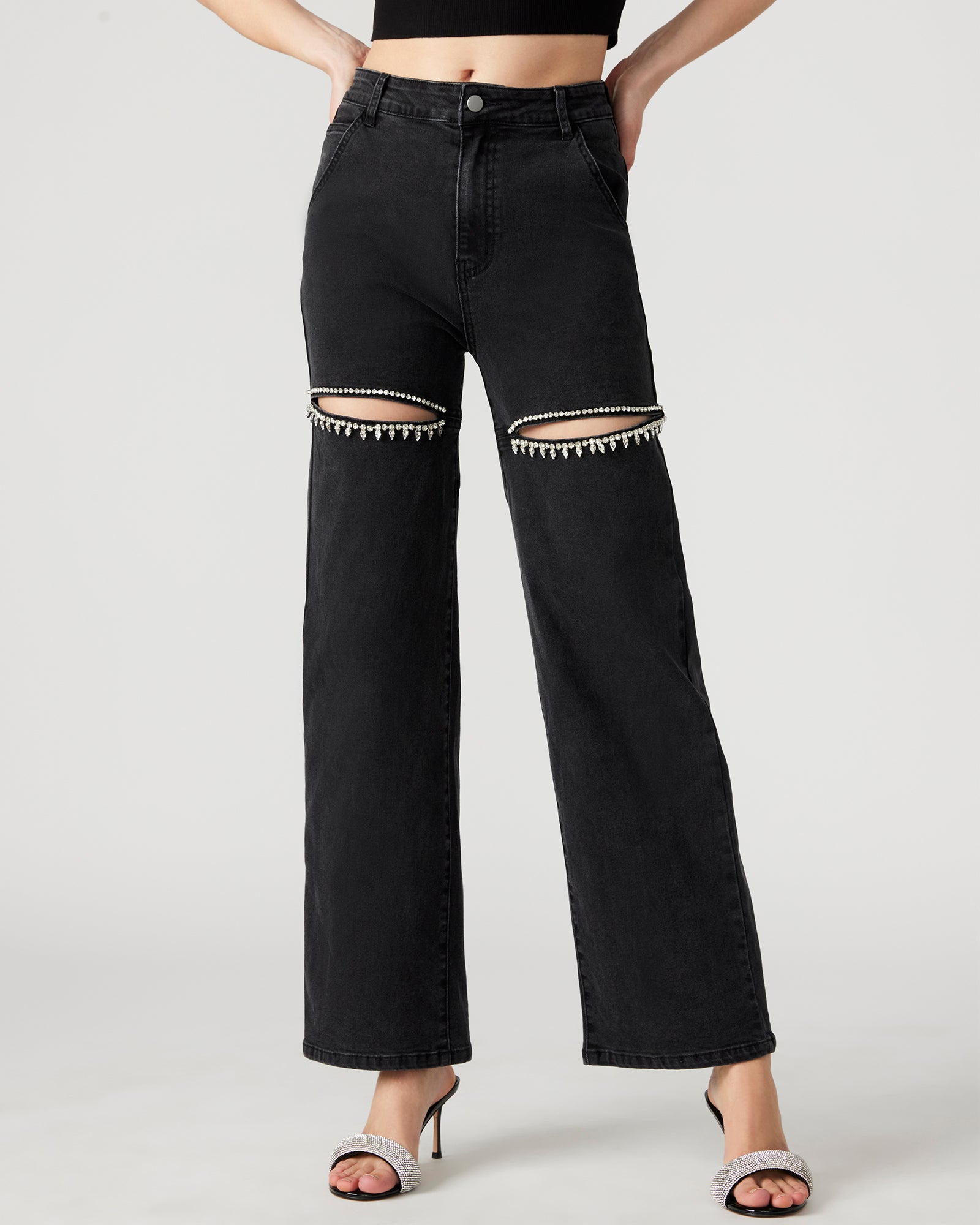 Model wearing wide leg jeans with rhinestone details, standing in a city setting