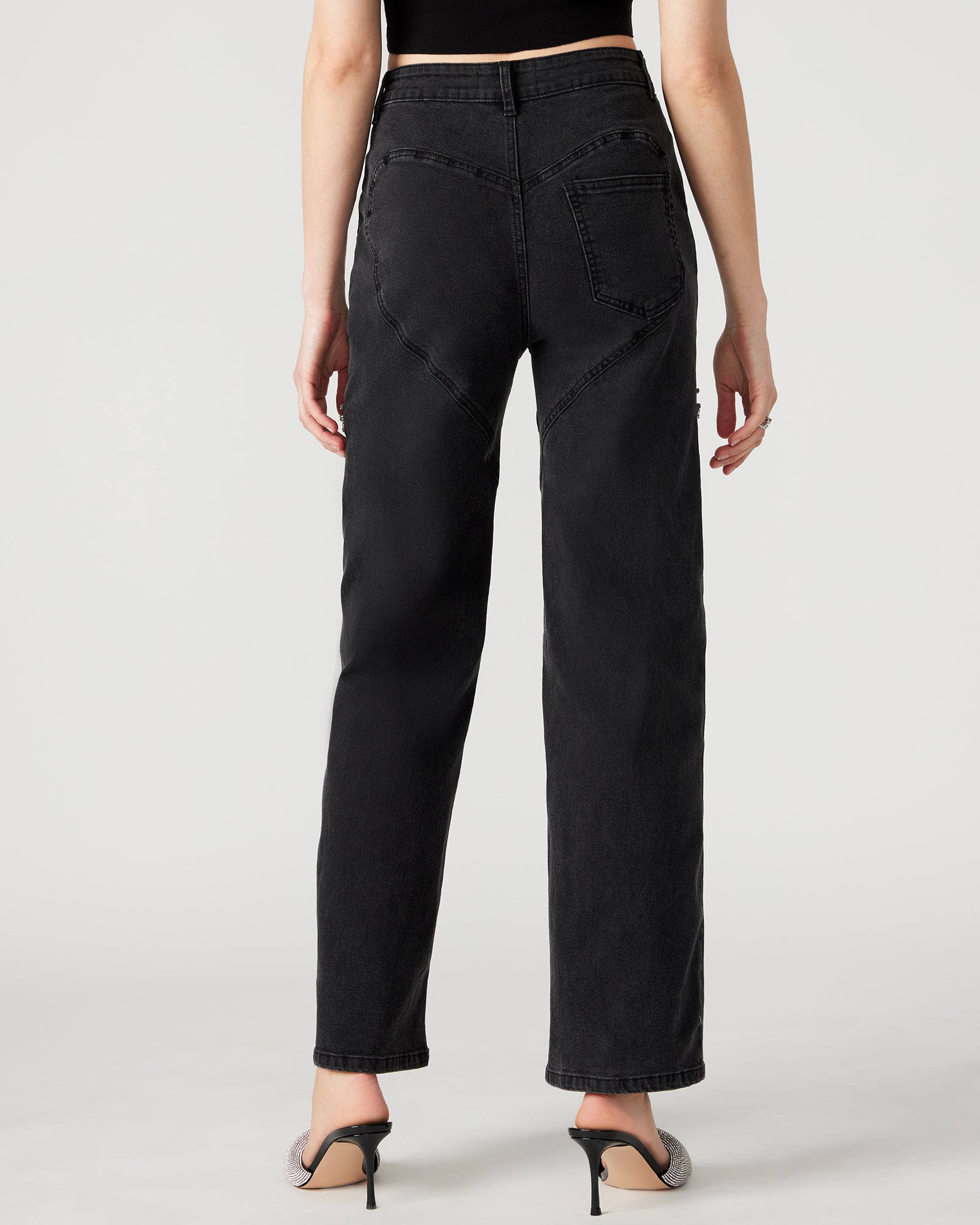 Close-up of rhinestone embellishments on the thighs of black wide leg jeans