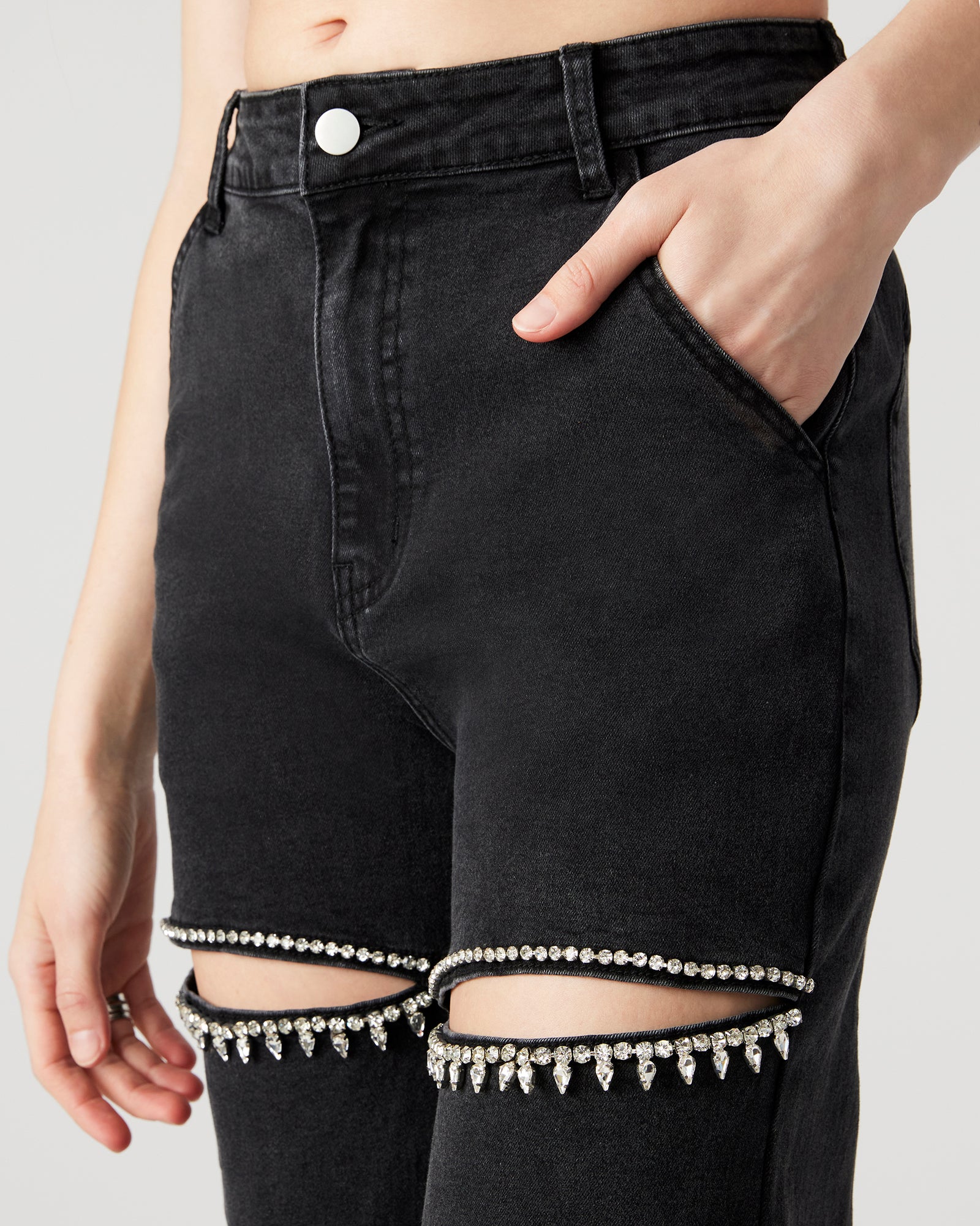 Model wearing wide leg jeans with rhinestone details, standing in a city setting