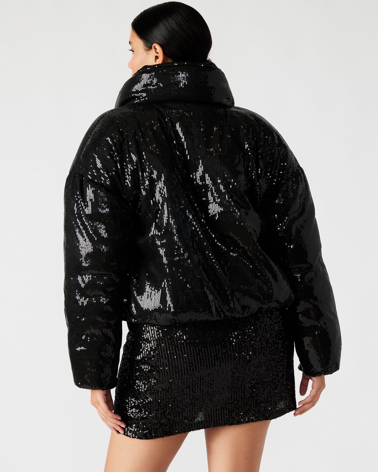 Side view of the womens black puffer jacket, highlighting its flattering fit.