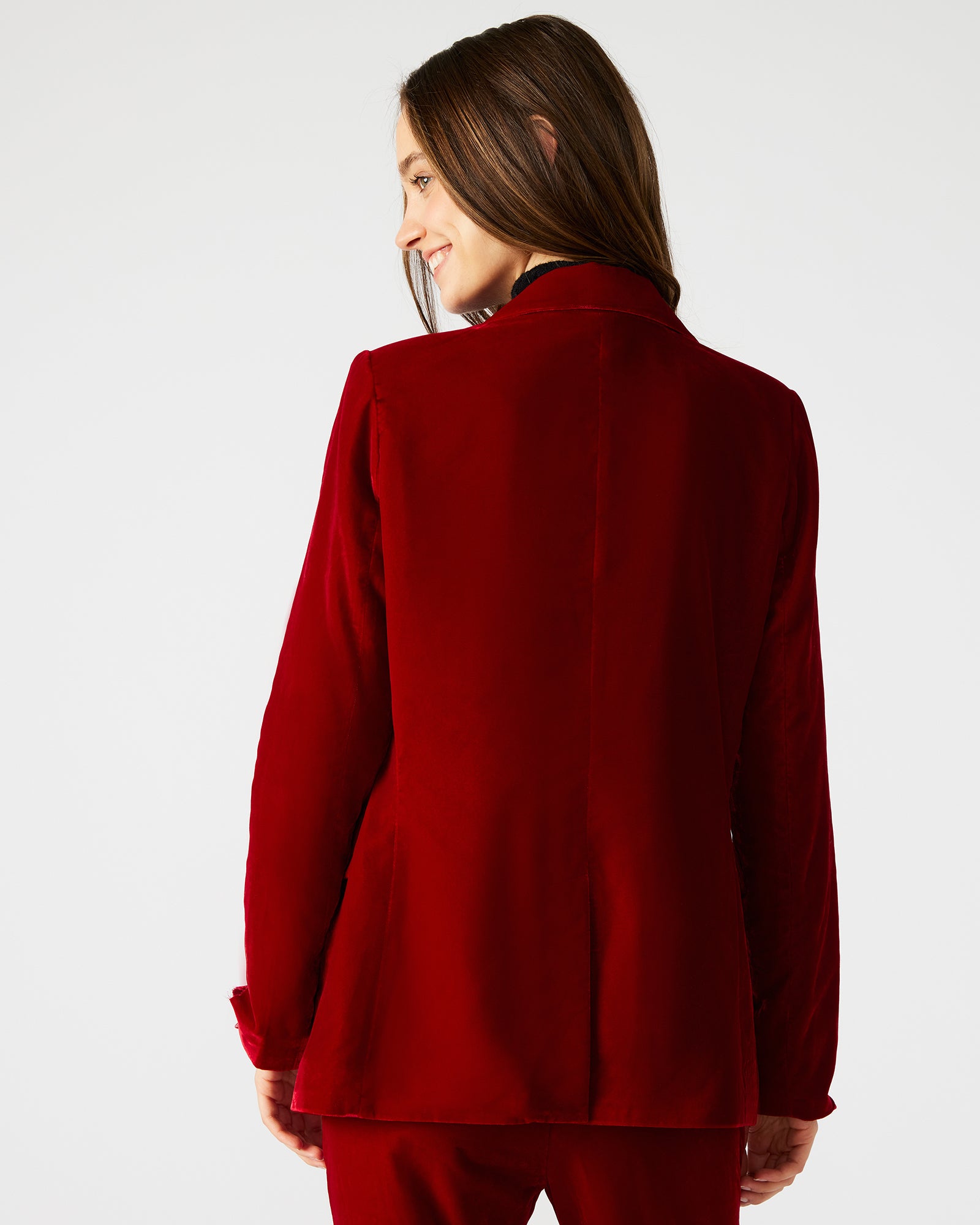 Close-up of the functional pockets on the red velvet blazer for women.