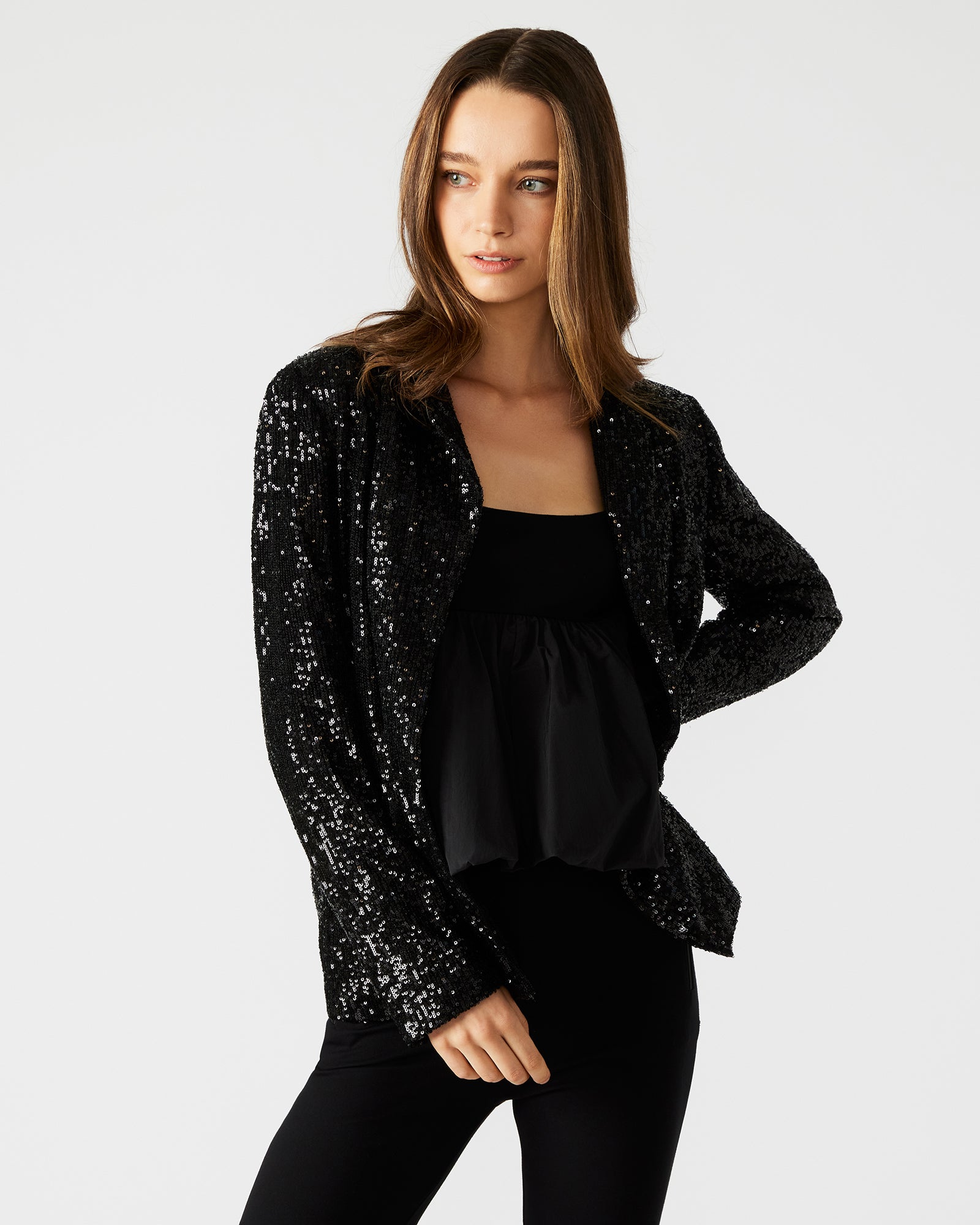 Close-up of blazer à sequins showing notched lapel and flap pockets.