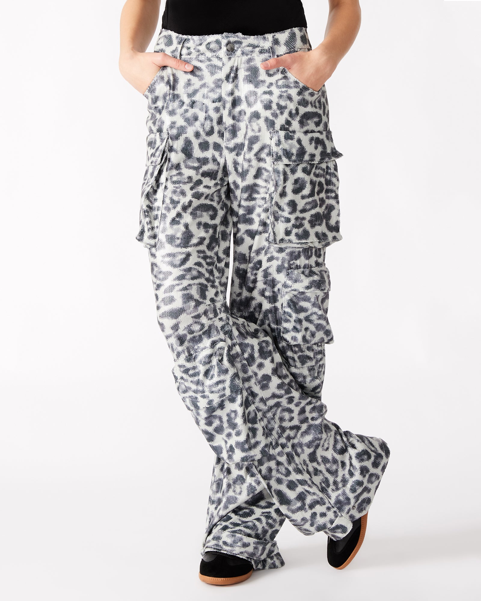 Close-up of cargo pockets on leopard print womens pants, featuring zipper pulls.