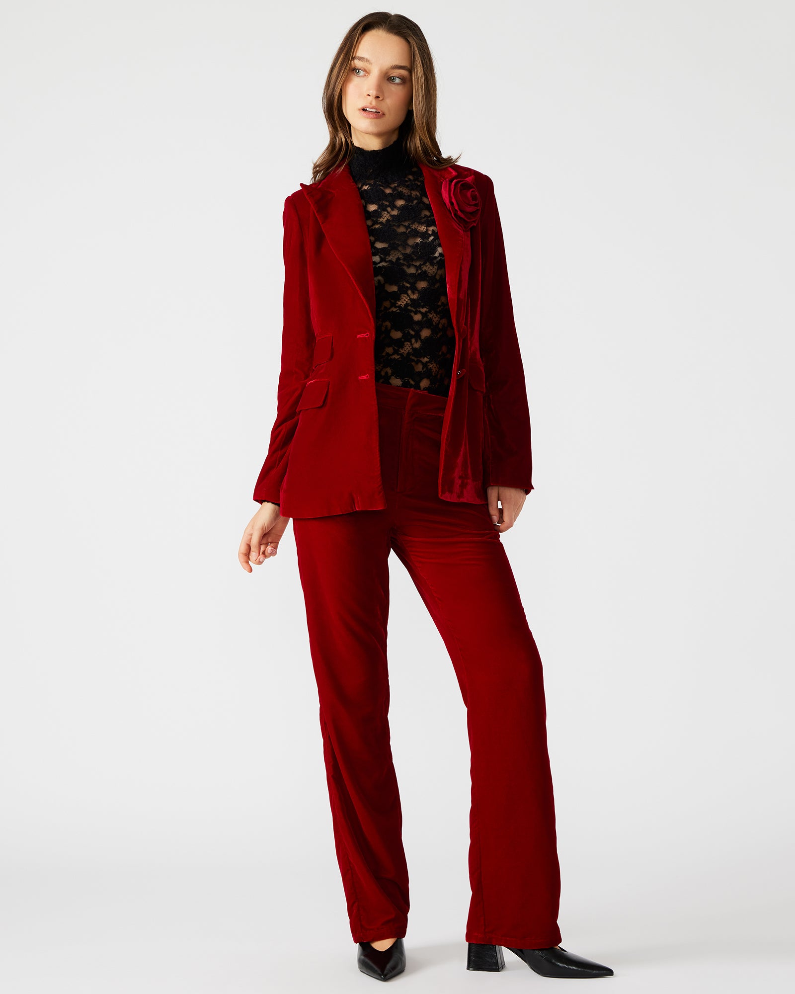 Front view of women’s red velvet pants styled with a blouse for a chic look