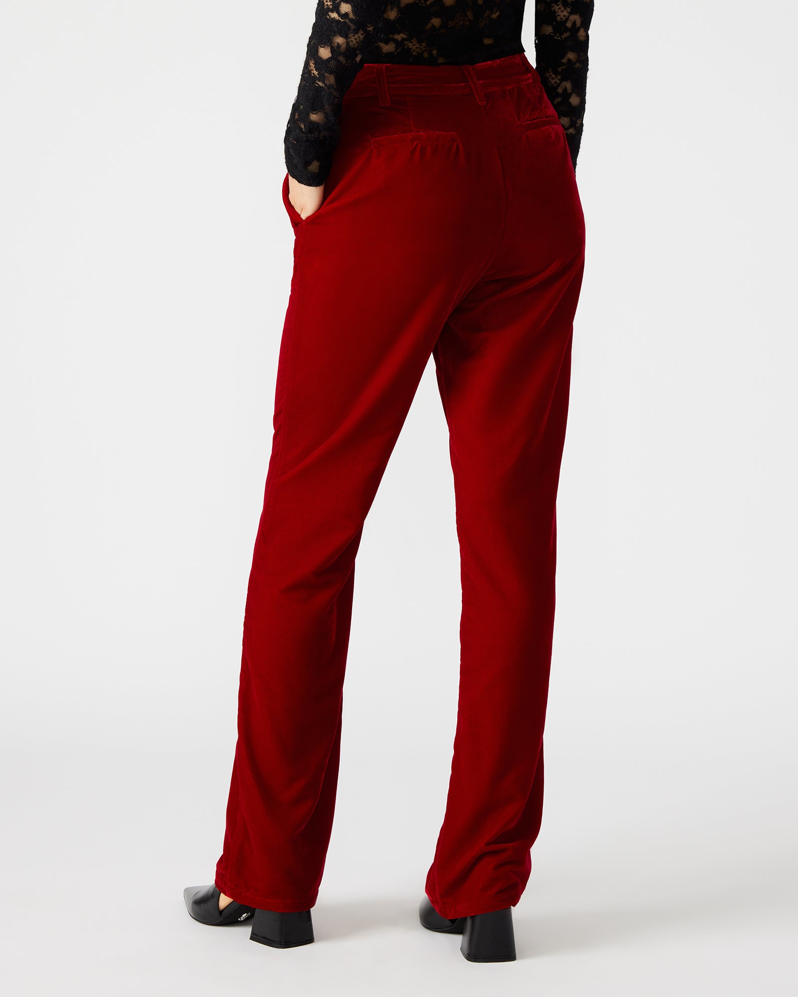 Model wearing black velvet pants with a blazer, showcasing versatile style