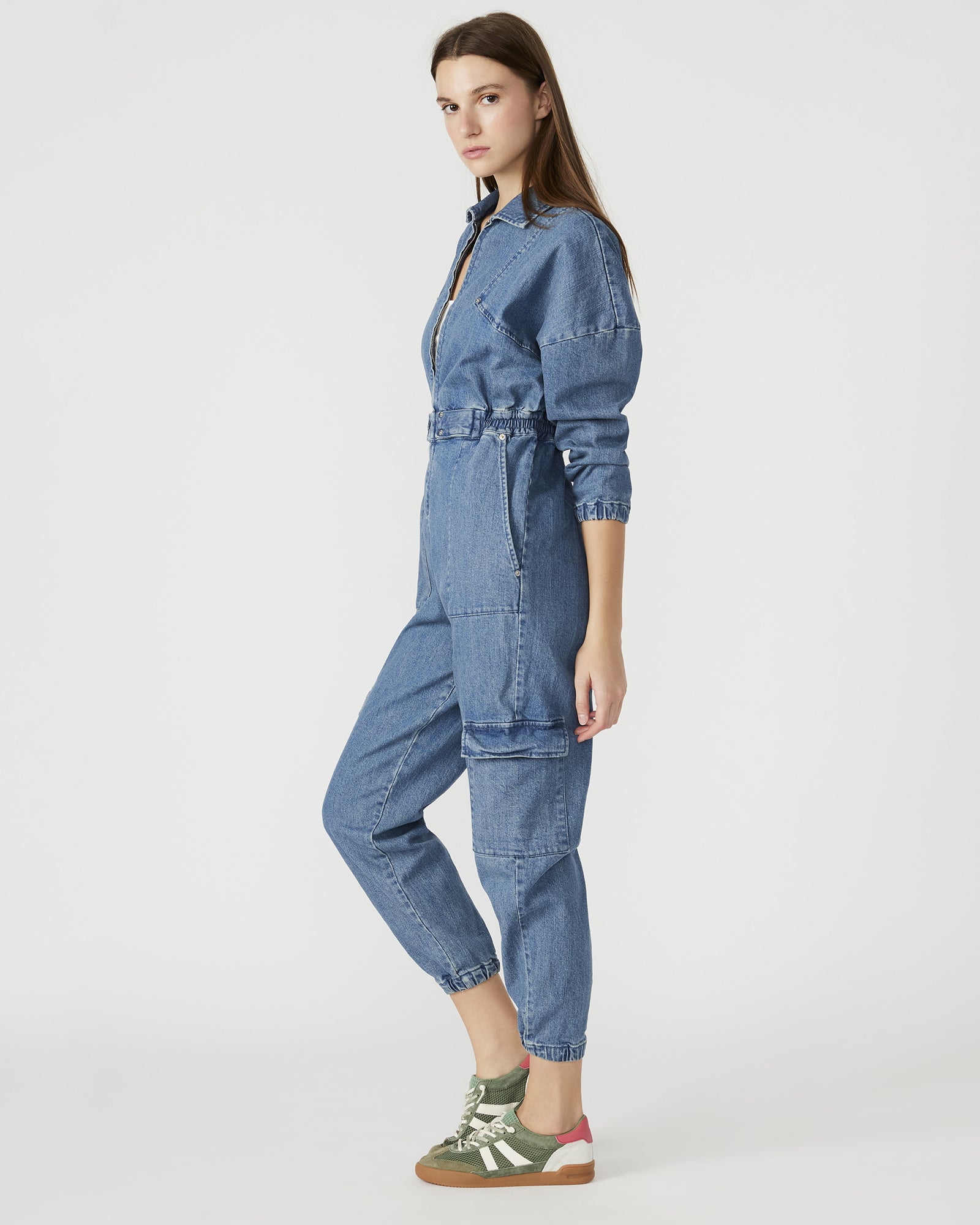 Side view of the black denim jumpsuit highlighting functional pockets.