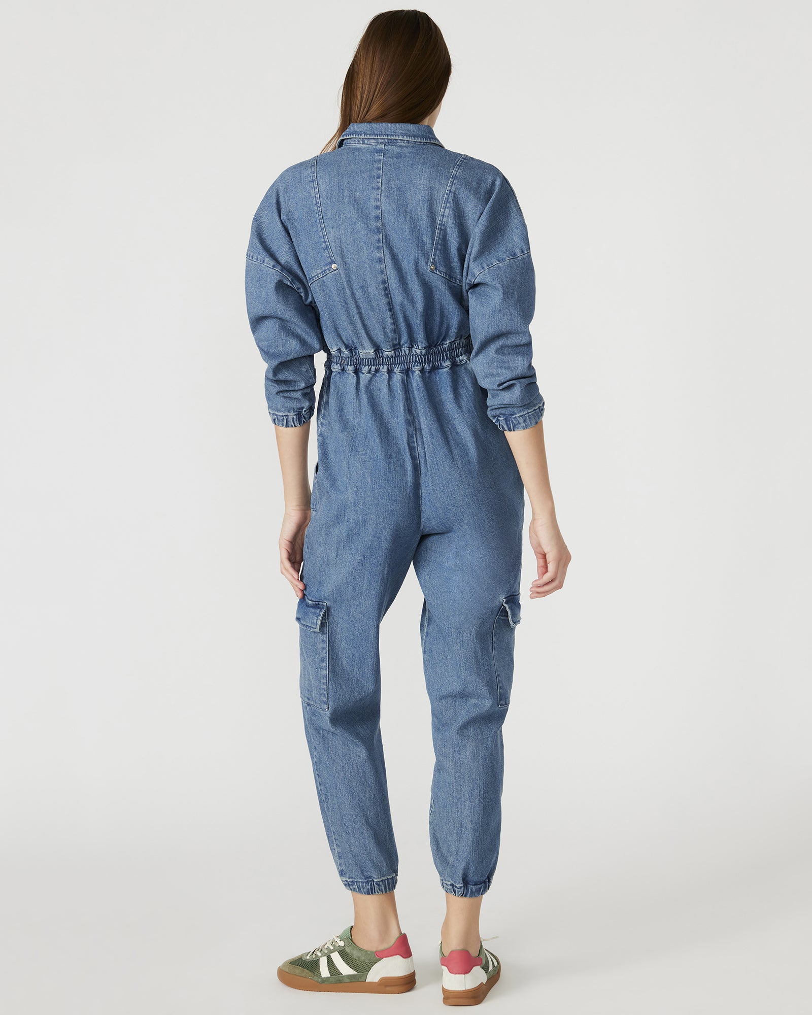 Model in a casual setting wearing the strapless denim jumpsuit.