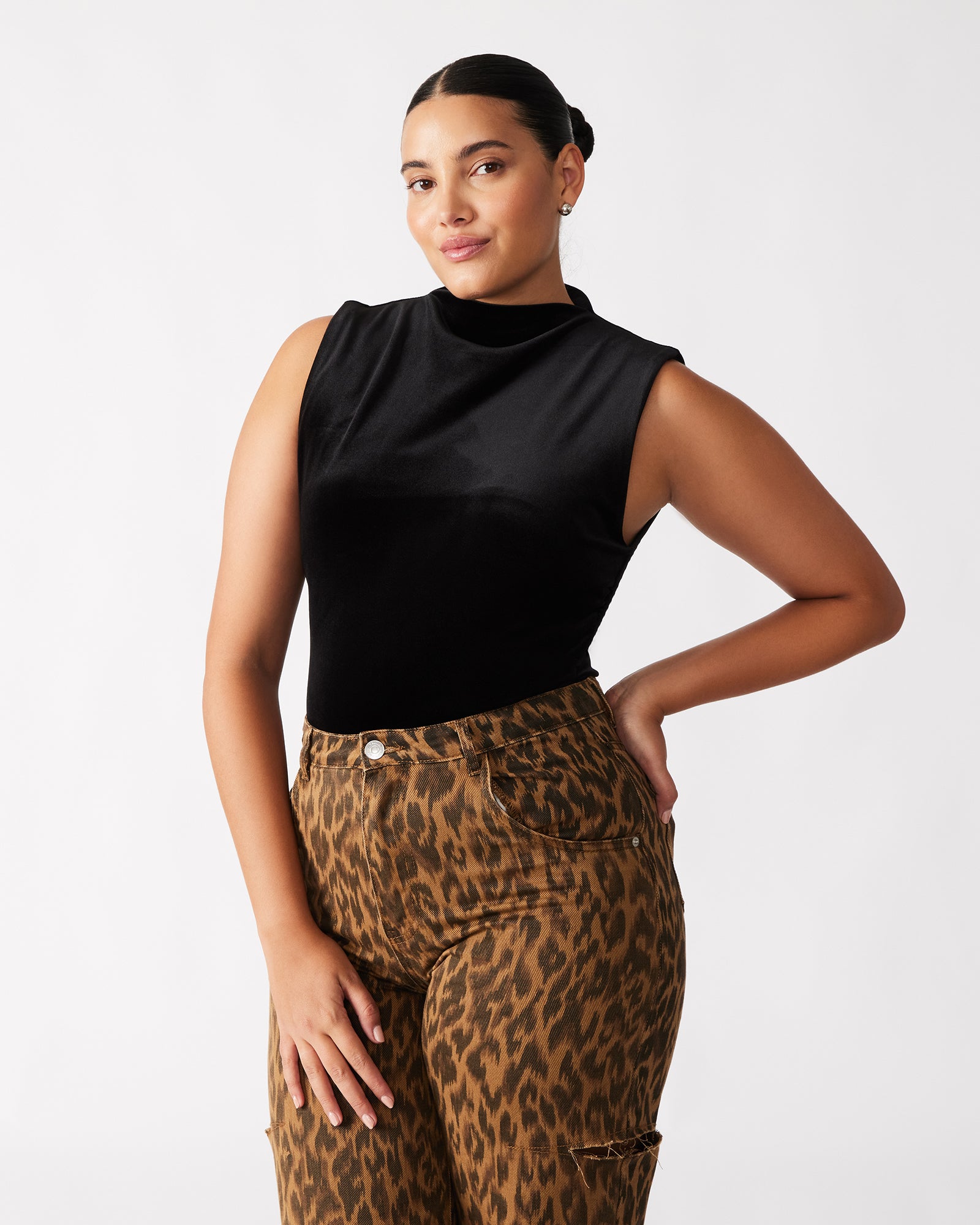 Model wearing the sleeveless bodysuit in a chic urban setting.