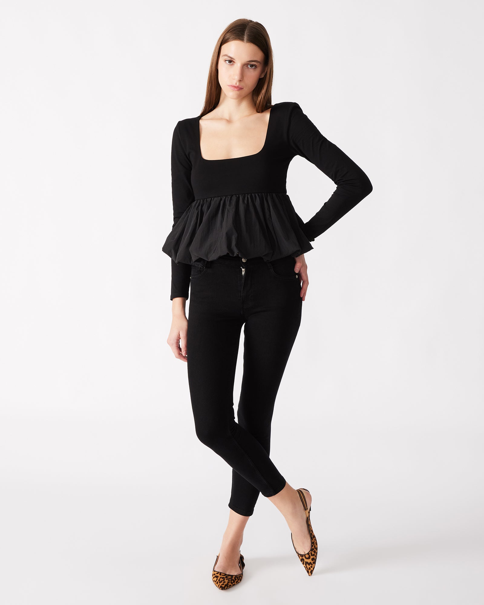 Black peplum top laid flat, showcasing the bubble hem design