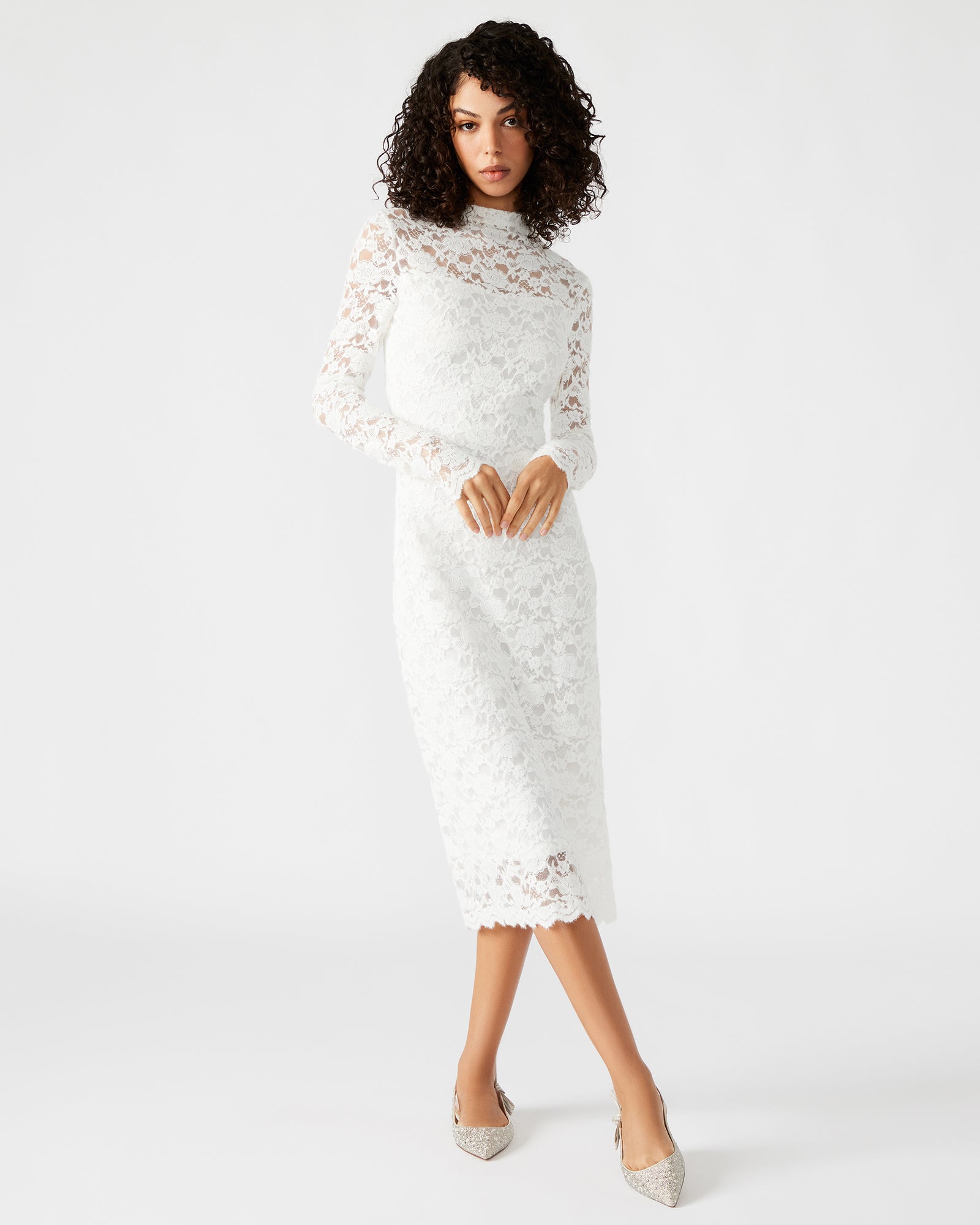 Side angle of the white lace dress worn with heels in a New York rooftop setting.