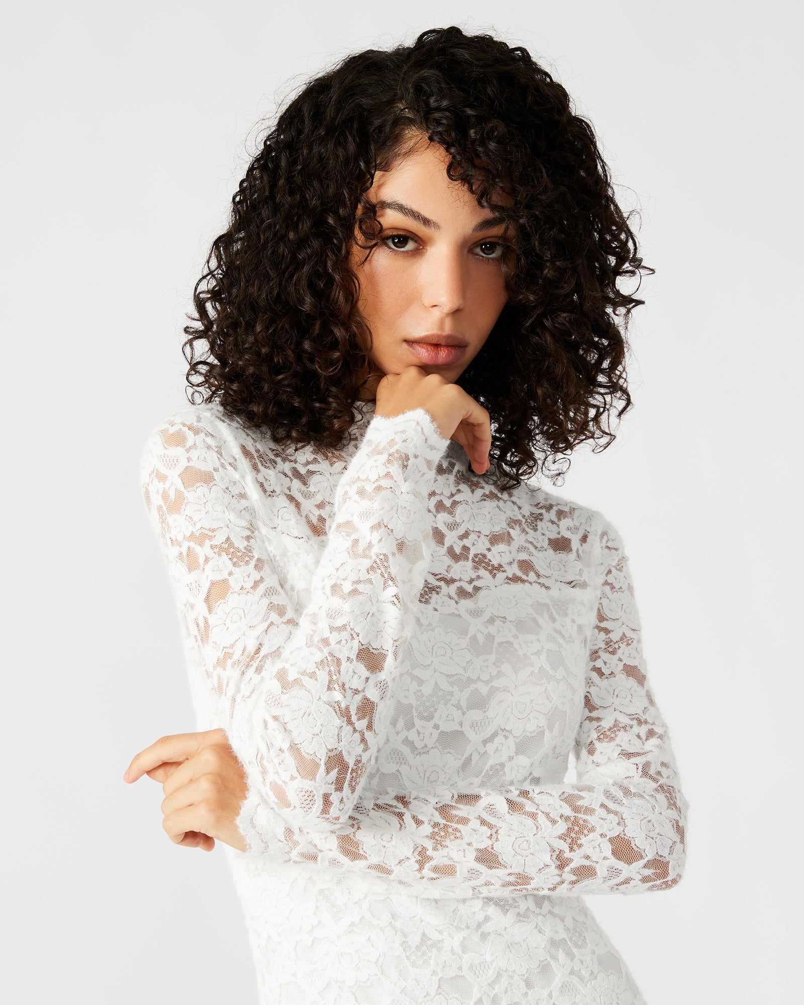 Close-up of the lace detailing on the mock neck and sheer sleeves of the ivory dress.